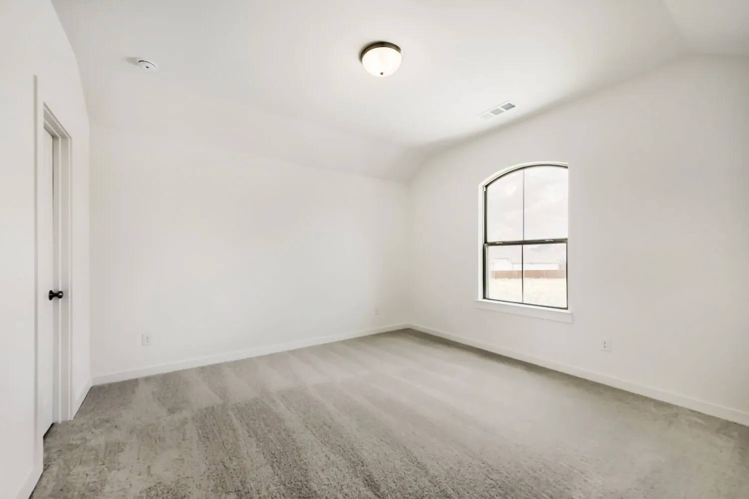 Neutral white wall paint, vaulted ceiling, and gray carpeted flooring