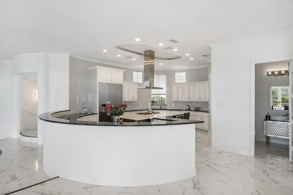 A striking contrast of white and black finishes, with sleek, custom cabinetry, a geometric angled island.