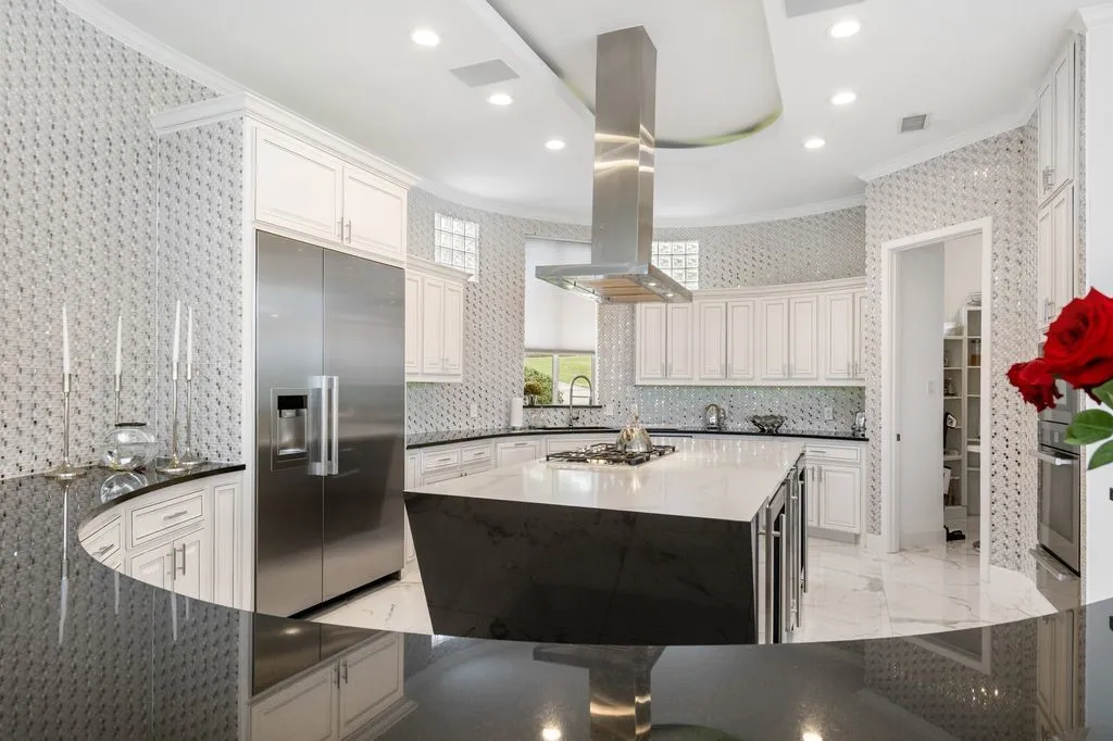 The gallery-style kitchen offers extensive cabinetry and a generously sized Quartz breakfast bar, providing ample seating.