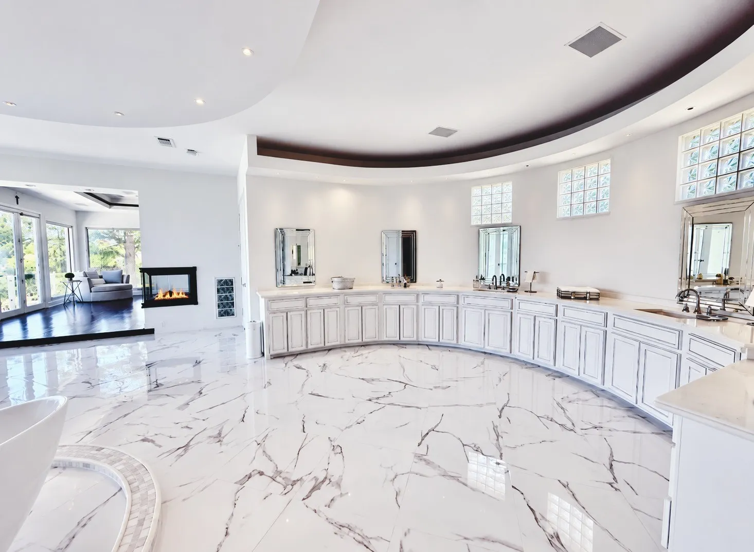 This expansive, curved vanity wall offers abundant custom cabinetry and generous open space, combining elegance with functionality.
