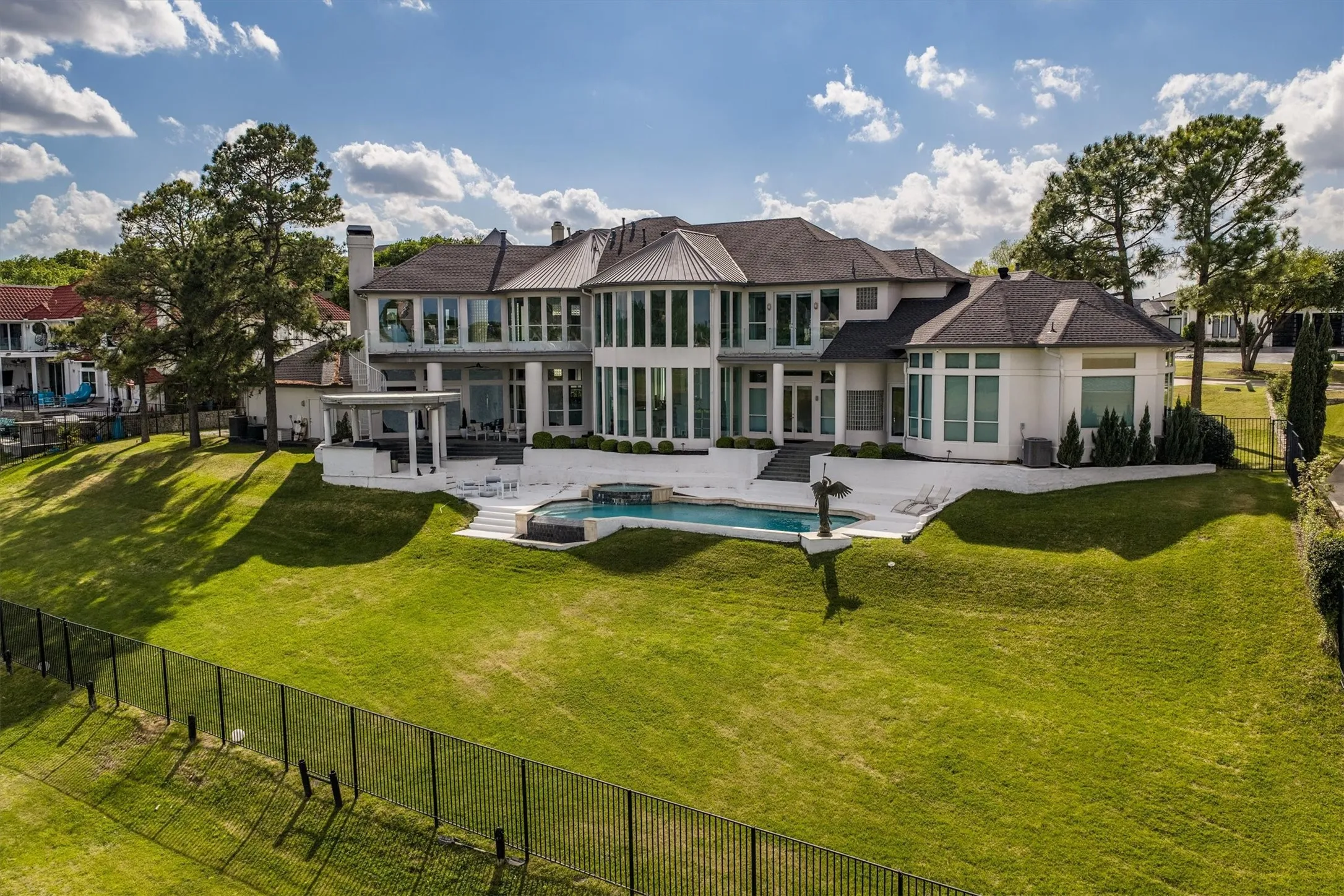 This luxurious estate offers expansive space for entertaining with a resort-style pool, a large built-in kitchen and patio, and ample grassy areas perfect to play or relaxation.