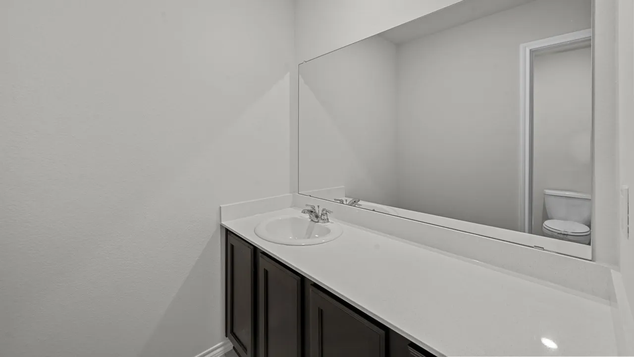 Extended vanity featuring a white countertop, undermount sink with chrome faucet, and dark wood-finish cabinetry