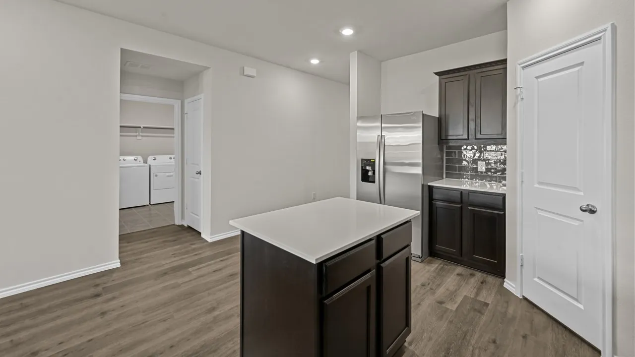 Kitchen island with white countertop, dark wood-finish cabinetry, and recessed lighting