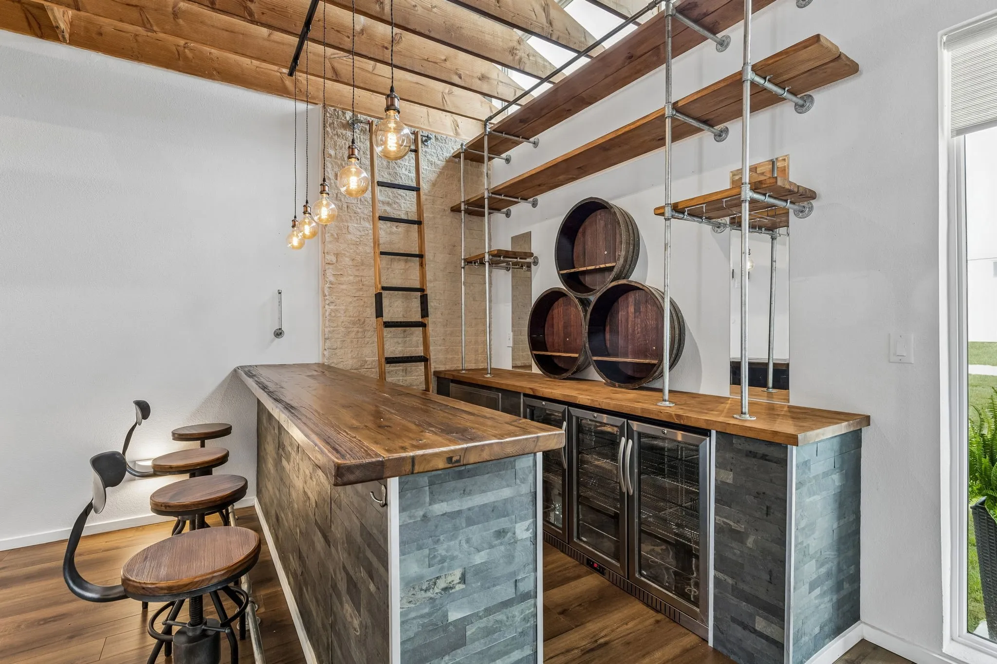 Close up of wood and steel bar with wine refrigerators which convey with the property.