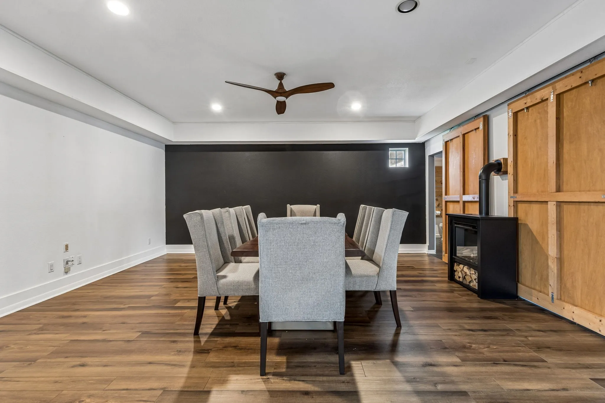 Large dining room with custom wood table made for the room!  Decorative electric fireplace with remote.  Two large barn doors.