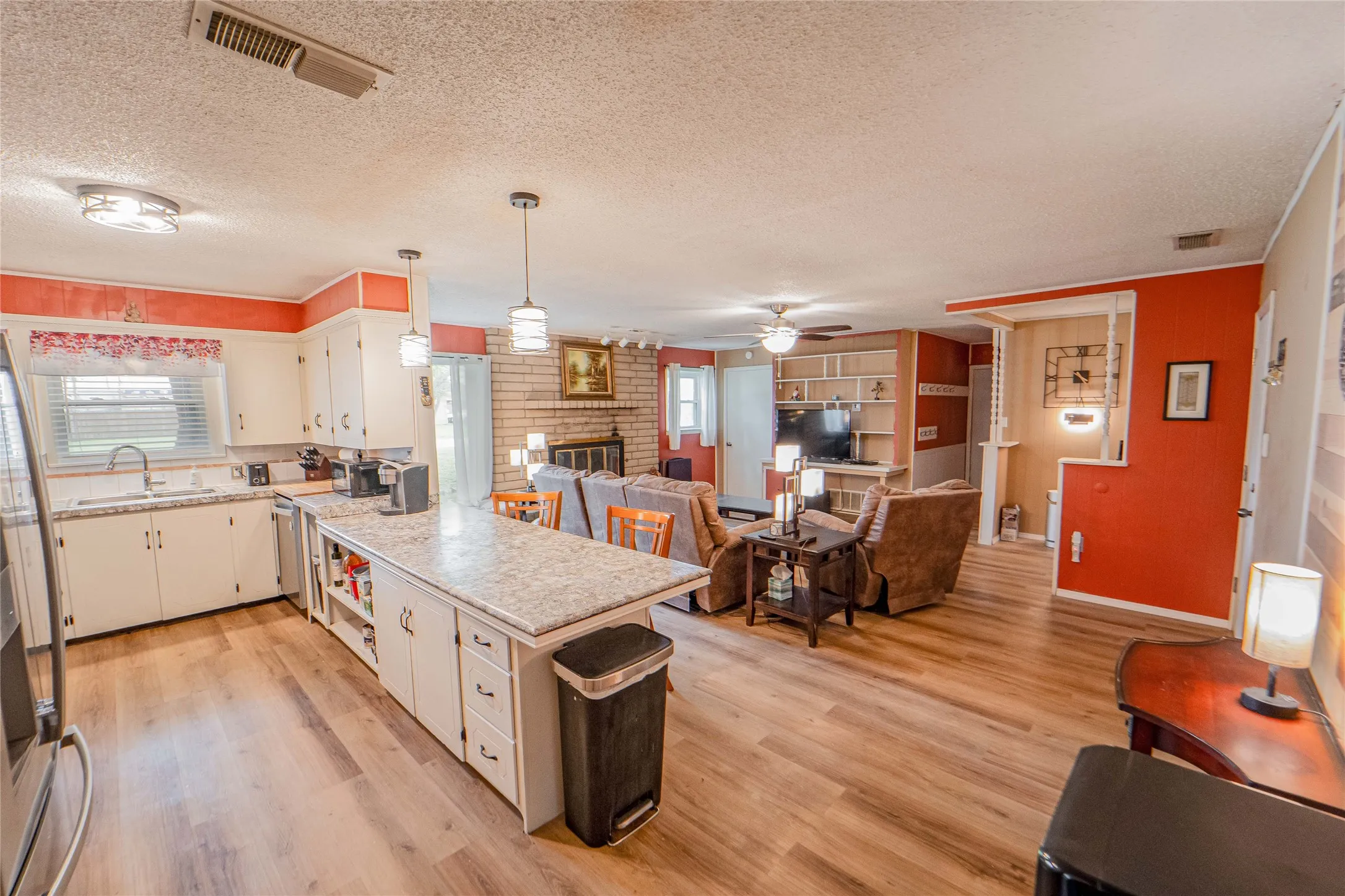 Kitchen with a peninsula, a fireplace, light countertops, open floor plan