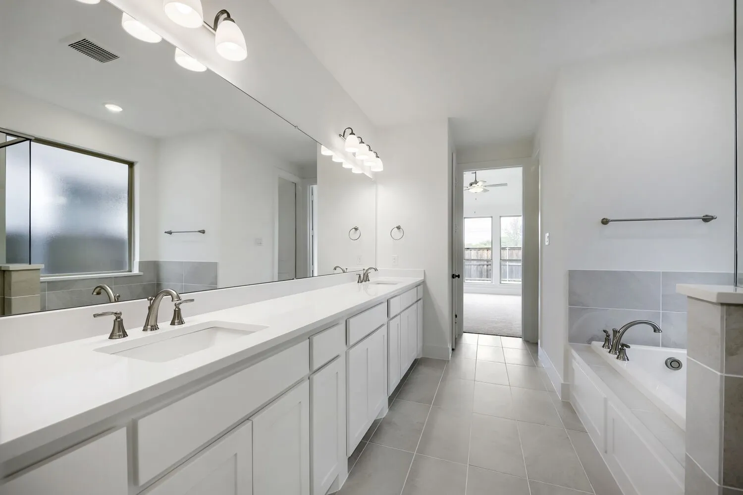 Dual vanity with white cabinetry and integrated sinks, complemented by brushed nickel fixtures