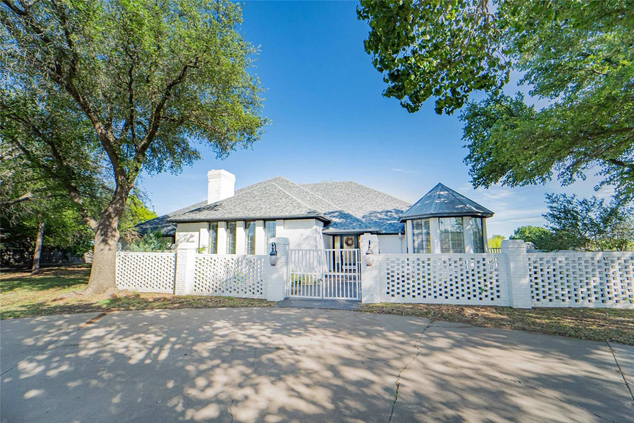 View of front of property with a fenced front yard, a chimney, and a gate