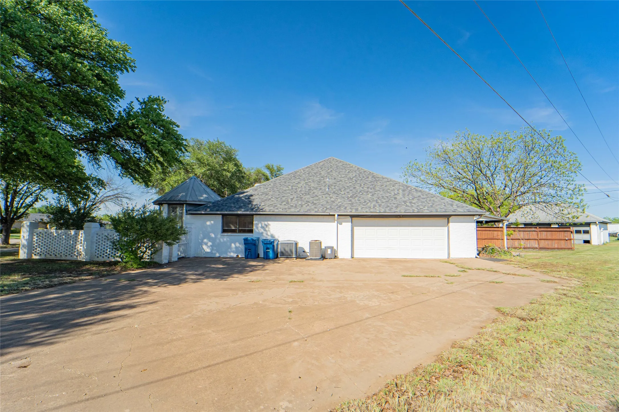 View of side of home with a shingled roof and driveway