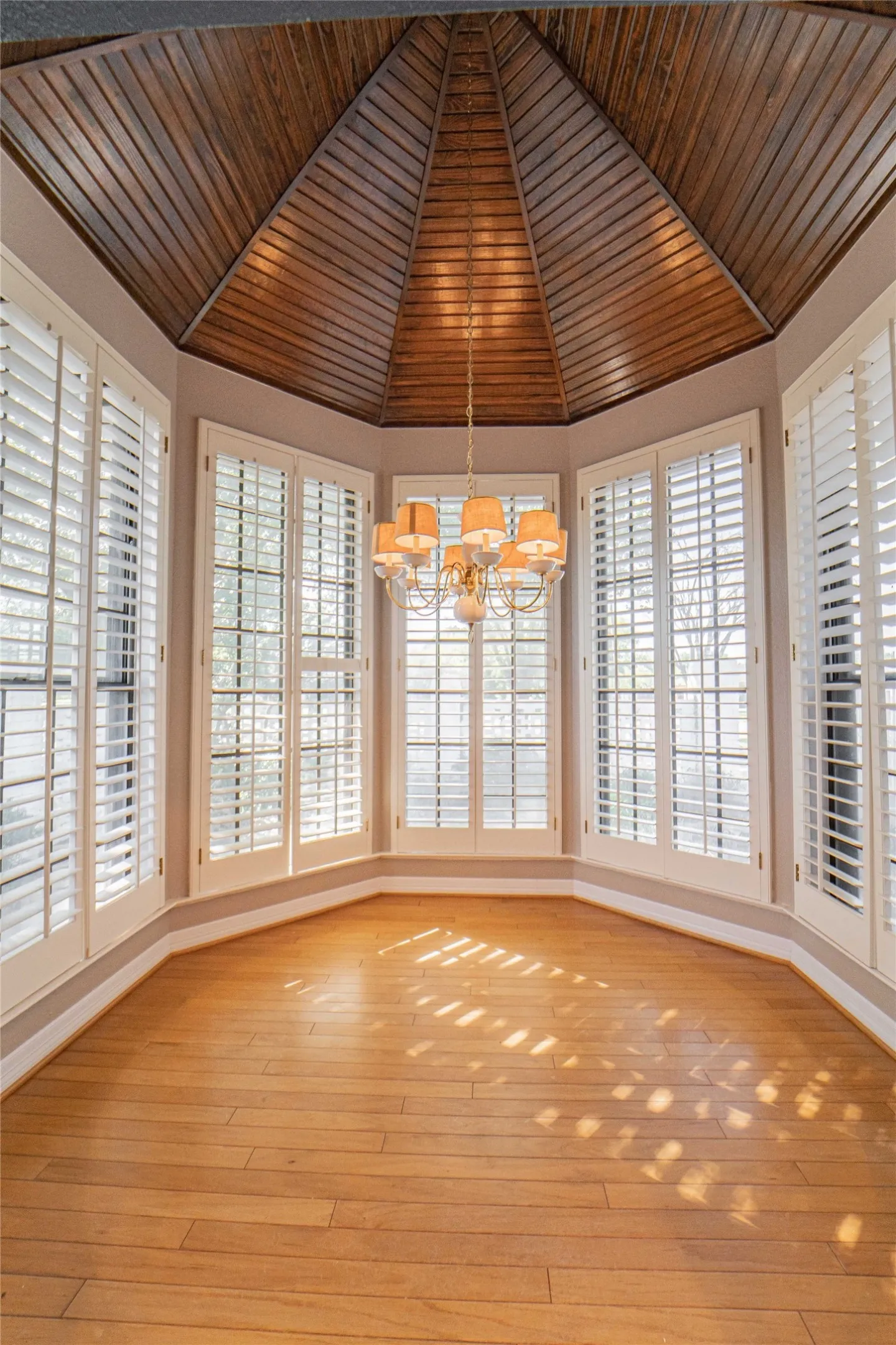 Breakfast room featuring a vaulted wood ceiling, suspended lighting, wood-type flooring, and plenty of natural light
