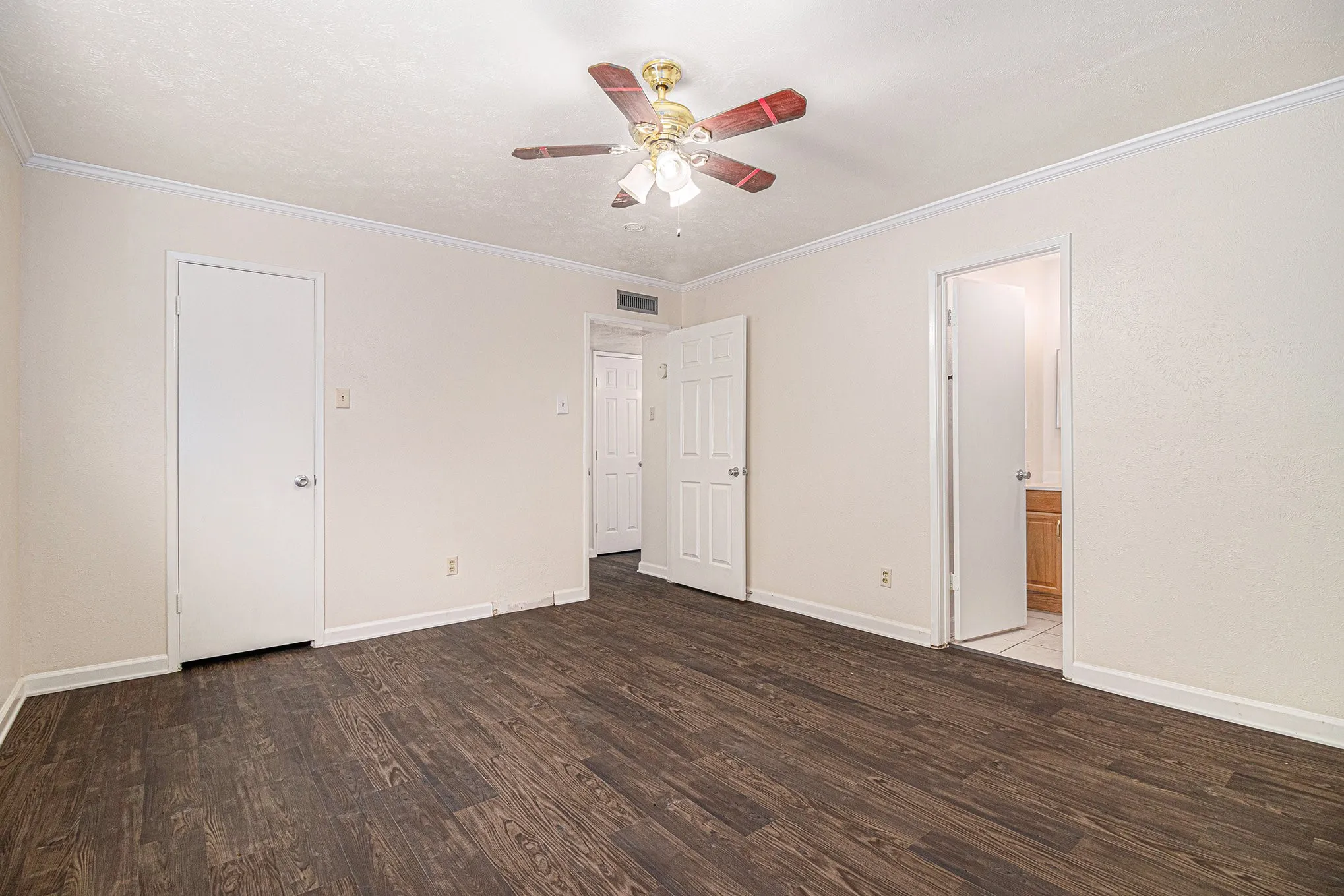 Spare room featuring ornamental molding, ceiling fan, and dark wood-type flooring