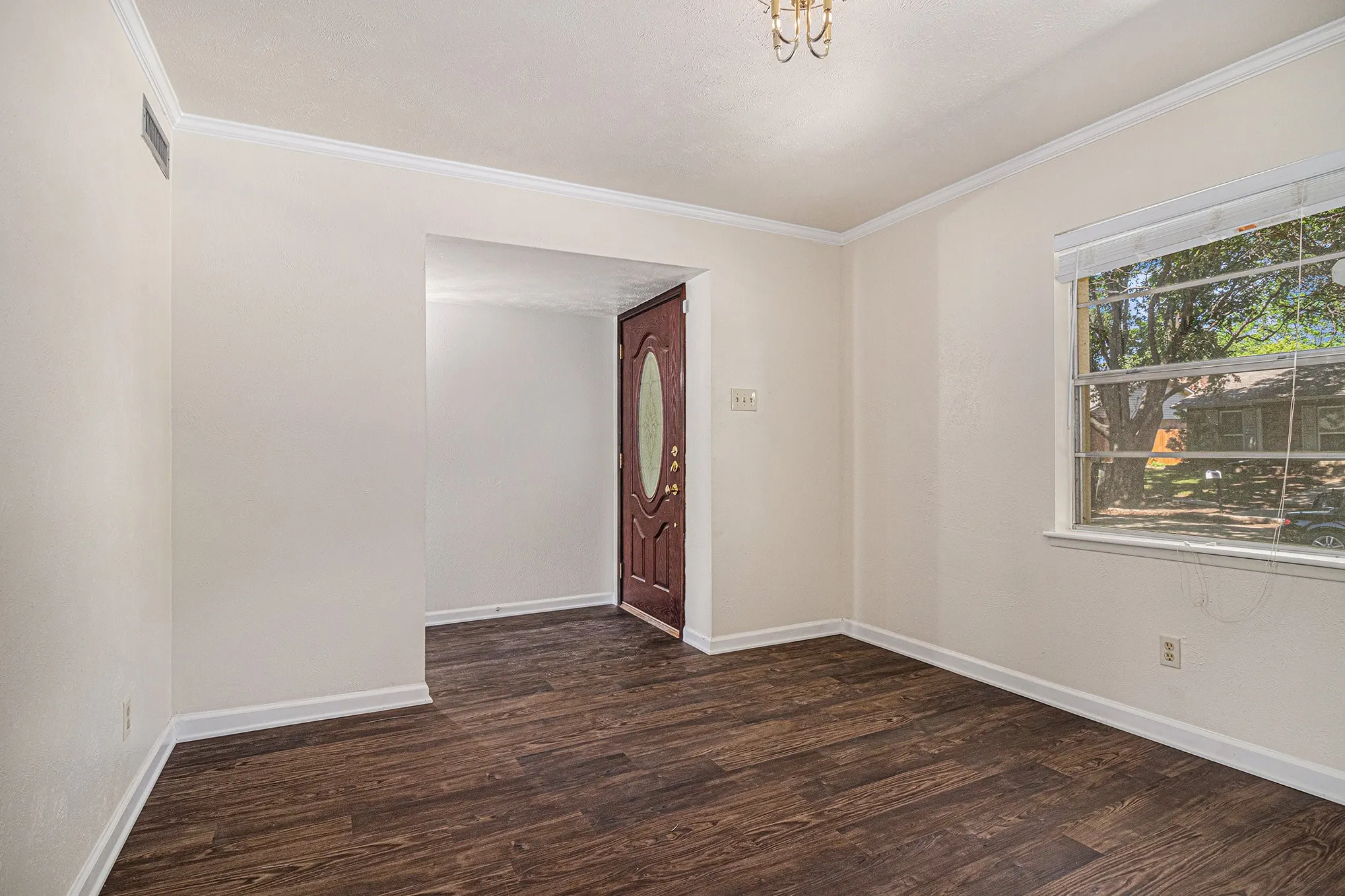 Unfurnished room featuring ornamental molding and dark wood-type flooring