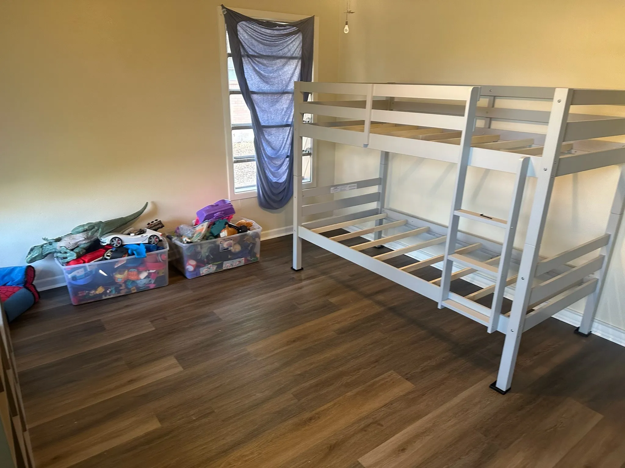 Bedroom with dark wood-style flooring and baseboards