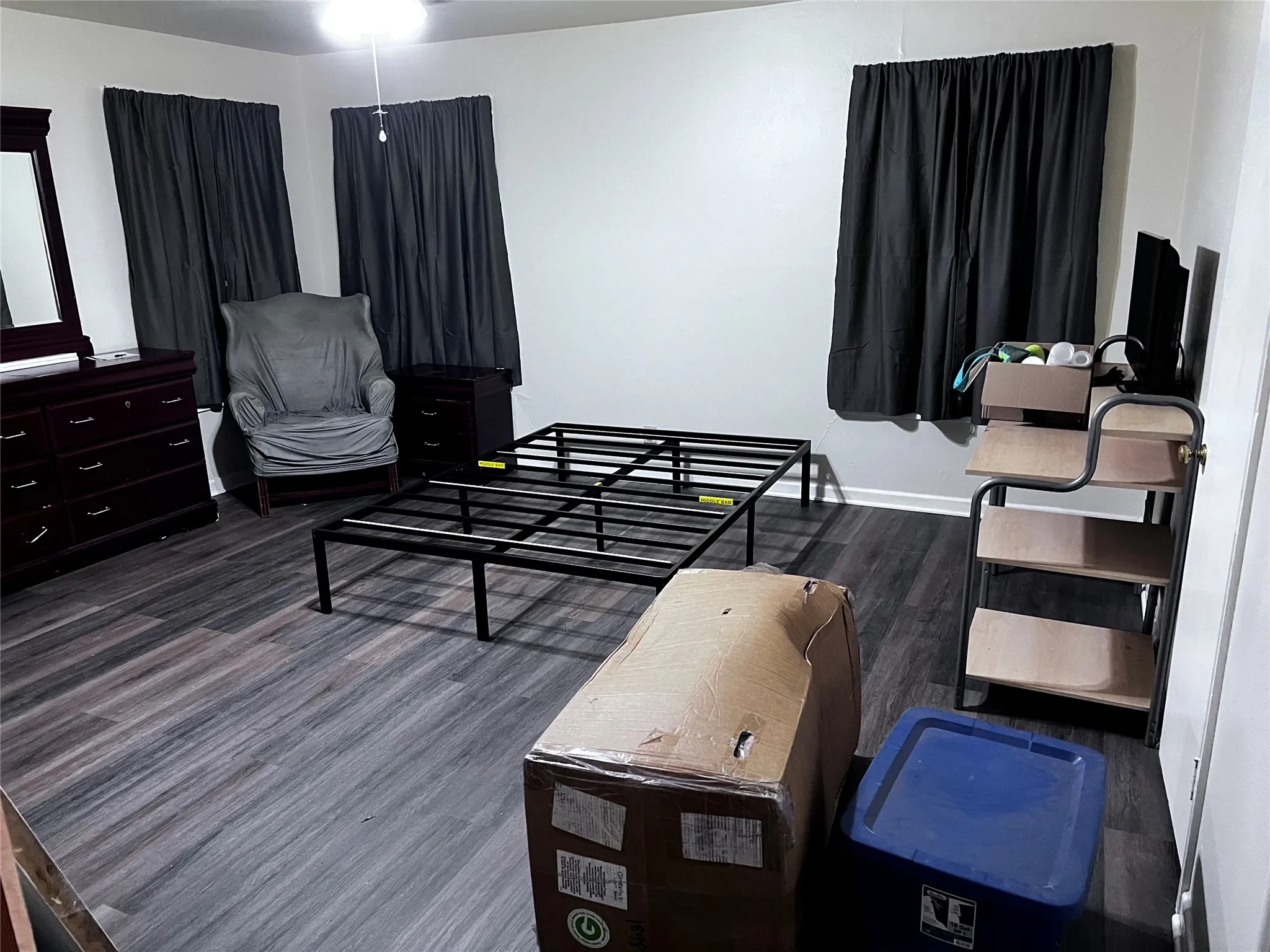 Bedroom with dark wood finished floors and baseboards