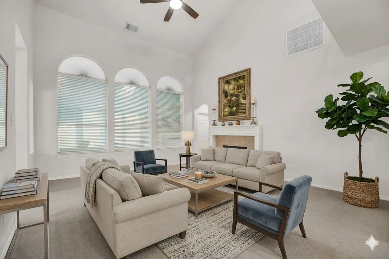 Living room with a tiled fireplace, ceiling fan, carpet floors, and lofted ceiling