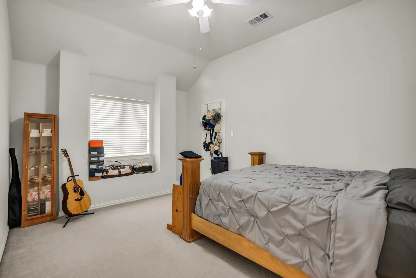 Bedroom with light carpet, vaulted ceiling, and ceiling fan