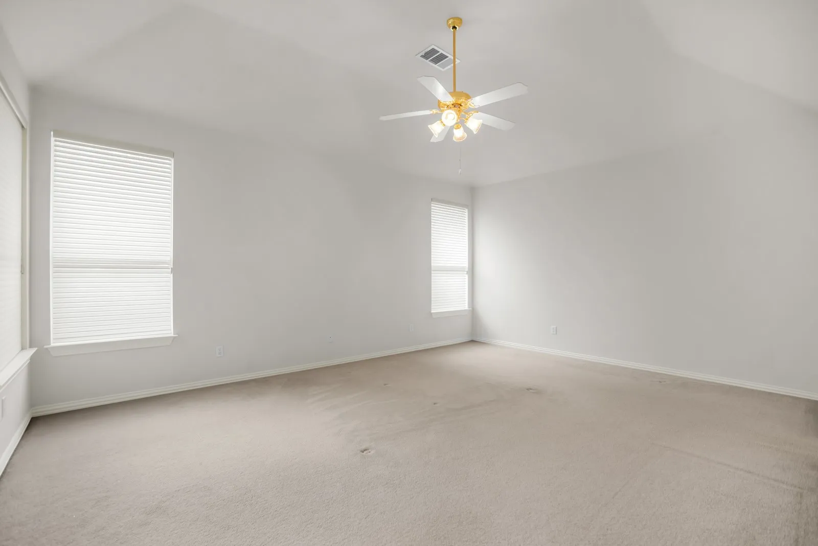 Empty room with carpet floors, ceiling fan, and lofted ceiling