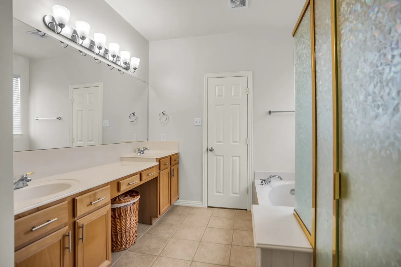 Bathroom featuring double vanity, a garden tub, light tile patterned floors, and a stall shower