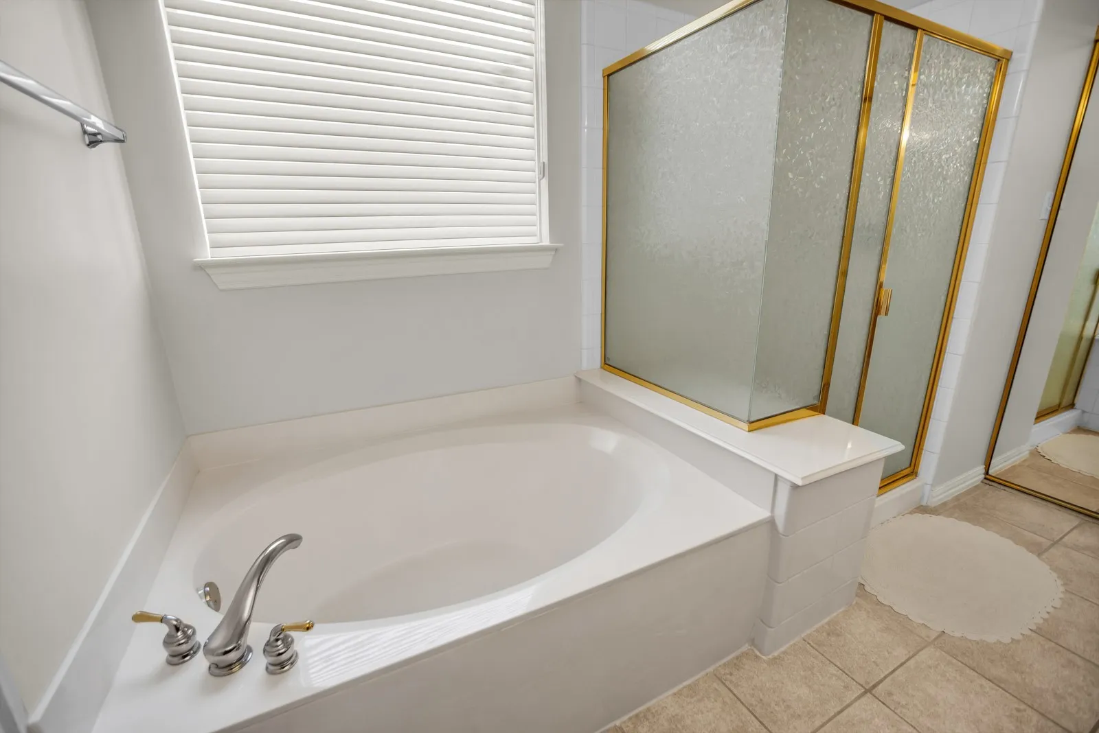 Full bath with a stall shower, a bath, and light tile patterned flooring