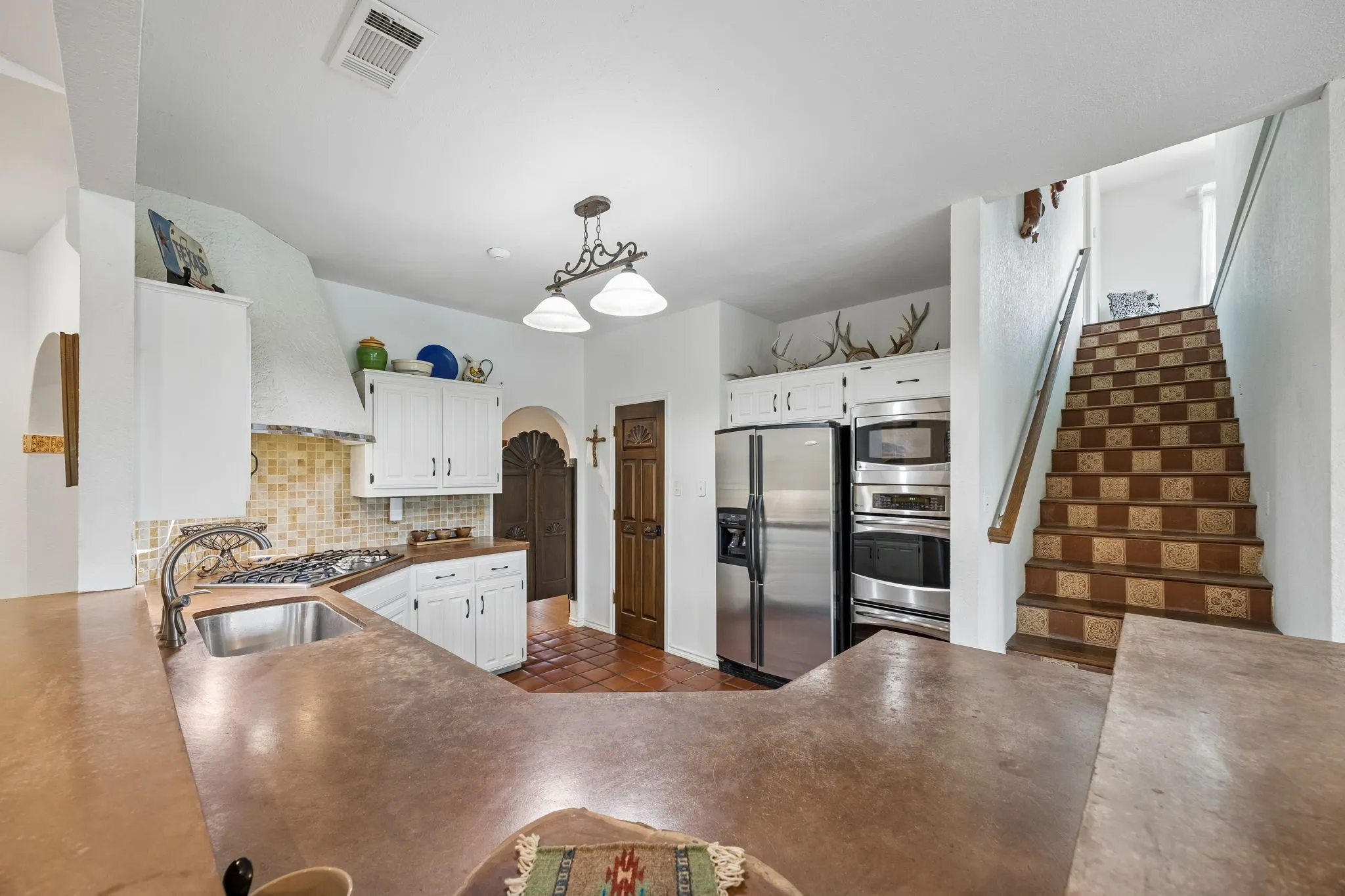 Kitchen featuring a gas cooktop, stainless steel appliances, white cabinetry, and a built-in oven