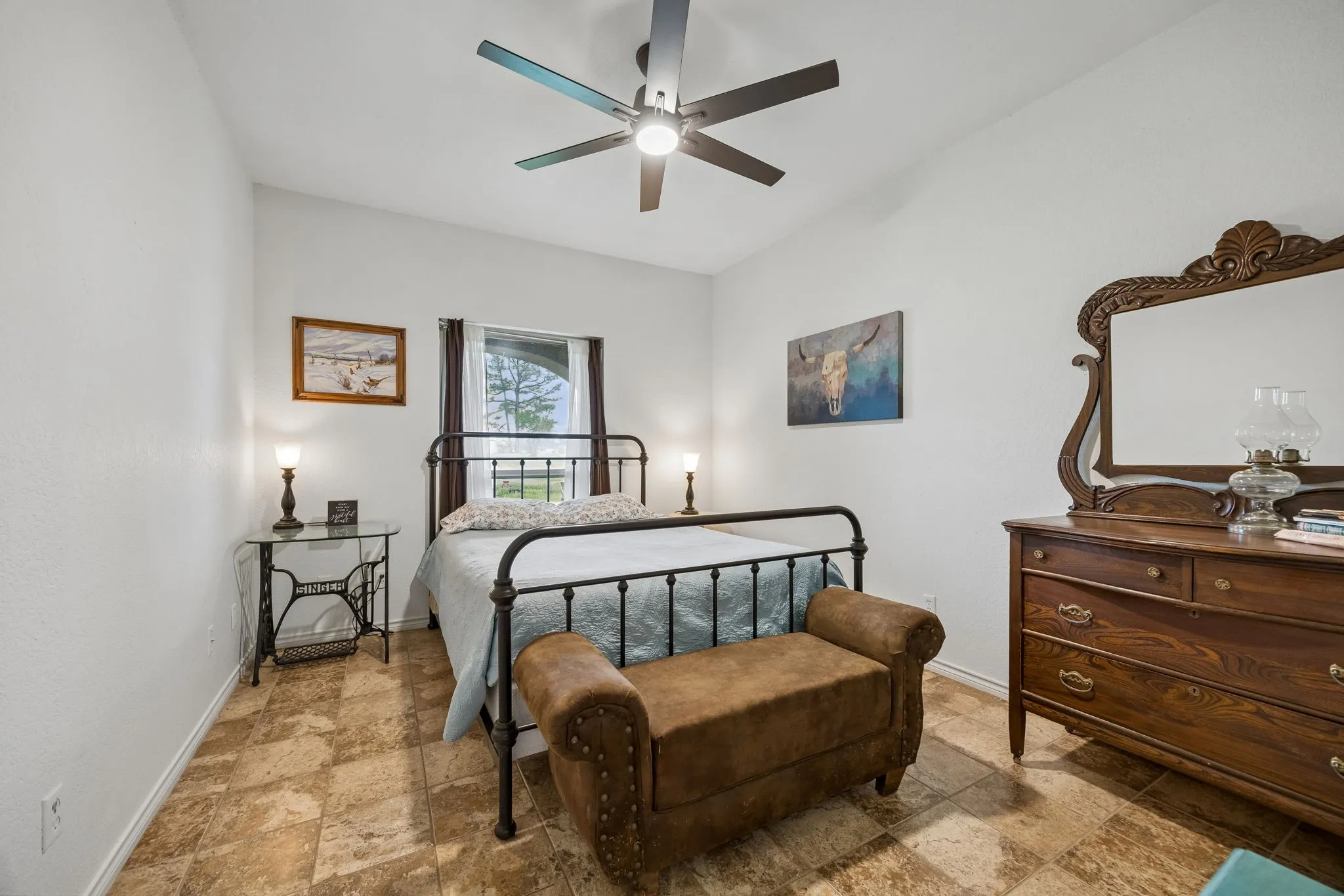 Spacious room featuring neutral tone walls, patterned tile flooring, and a window with dark framing