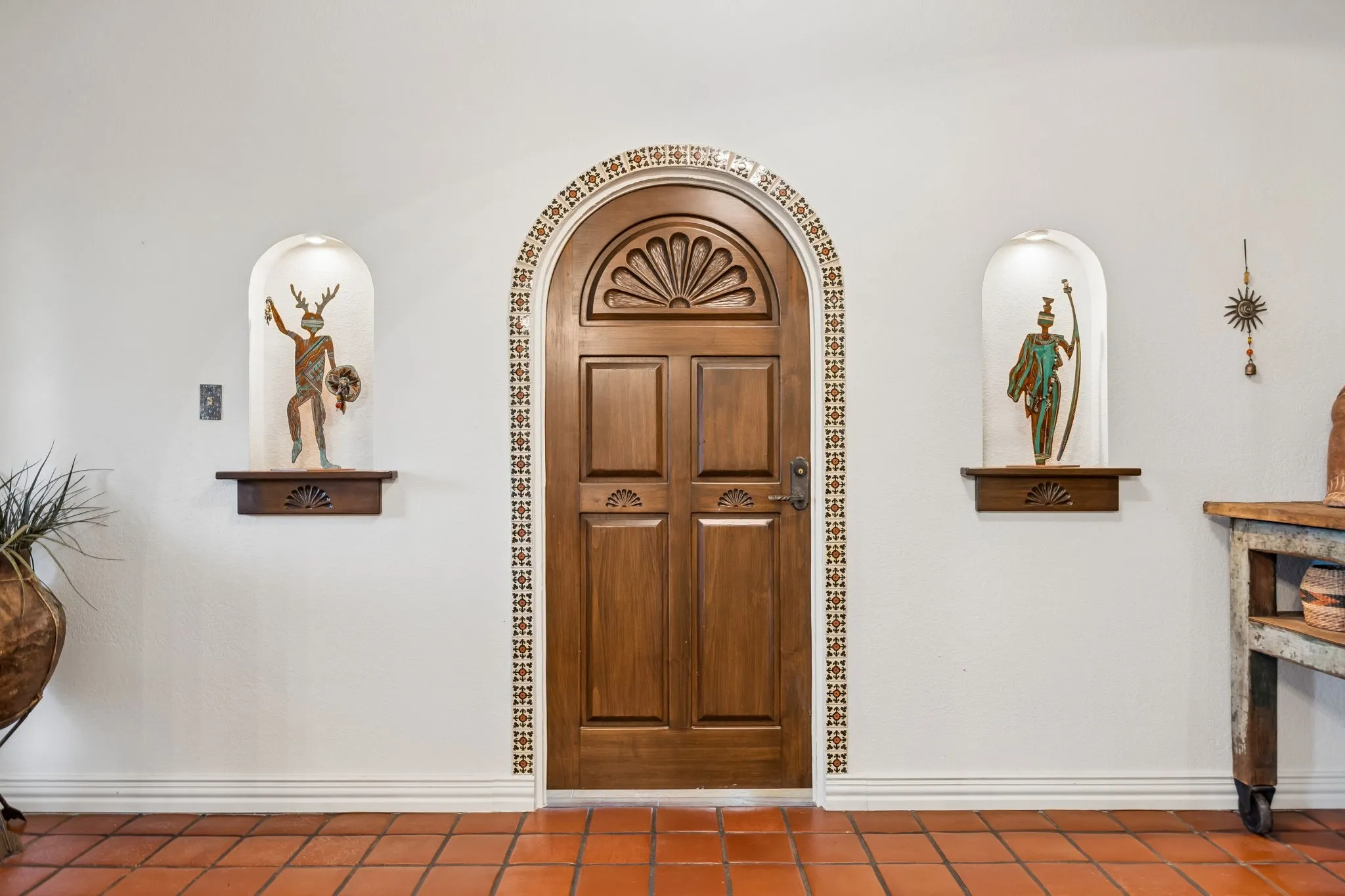 Gorgeous custom door from New Mexico, framed by mosaic tile detailing, and decorative niches
