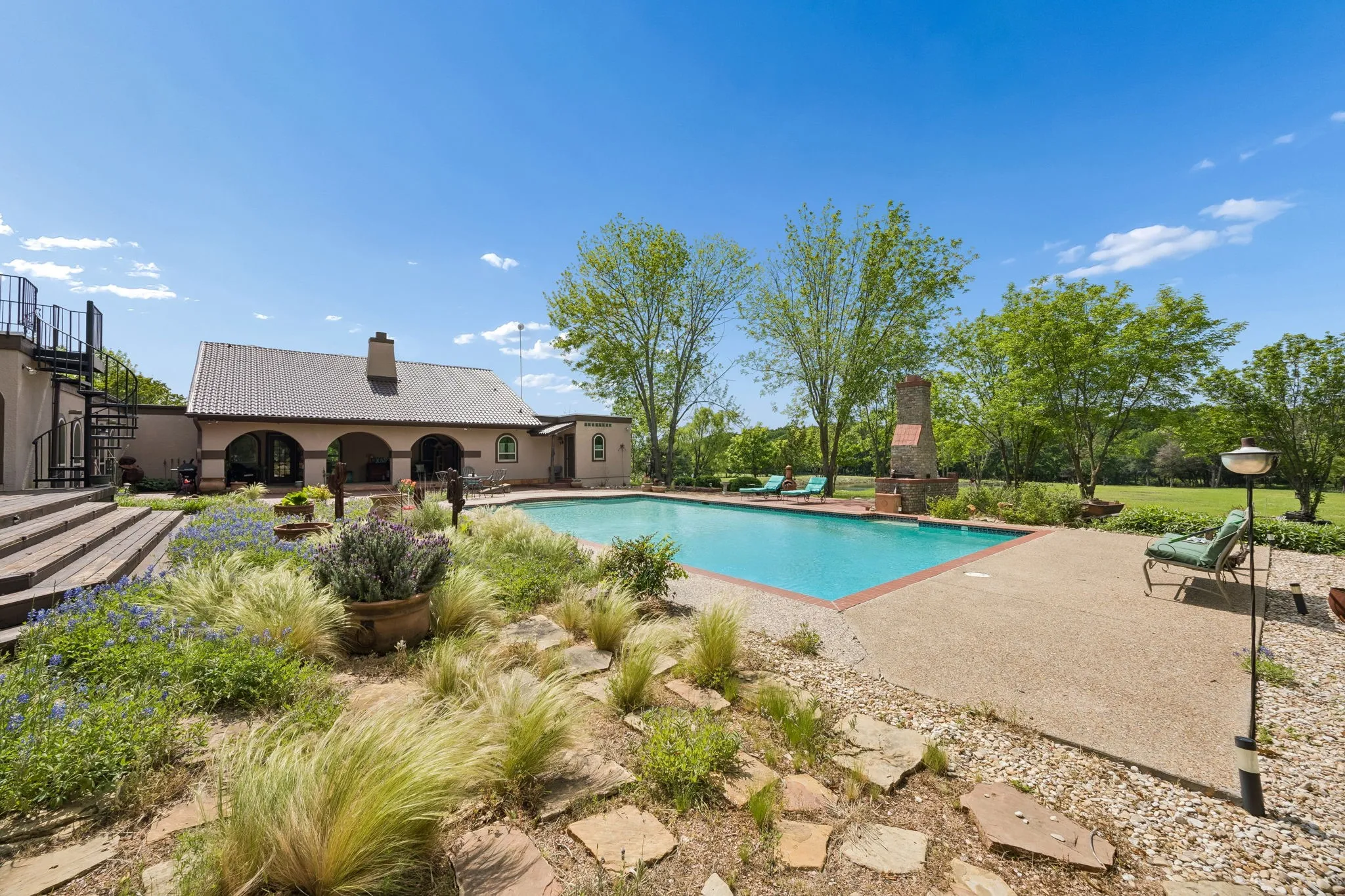 Outdoor swimming pool with an exposed aggregate deck and brick coping