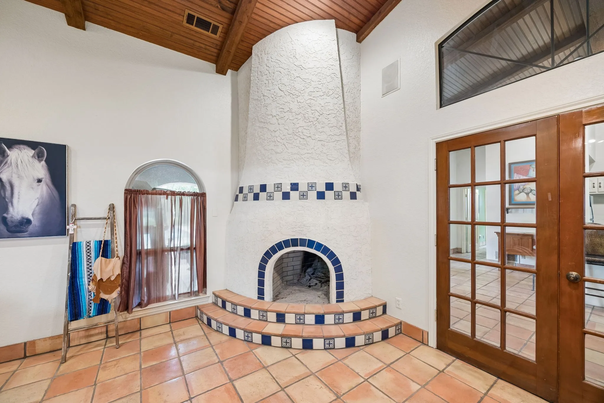 Kiva fireplace featuring a tiled hearth and decorative accents