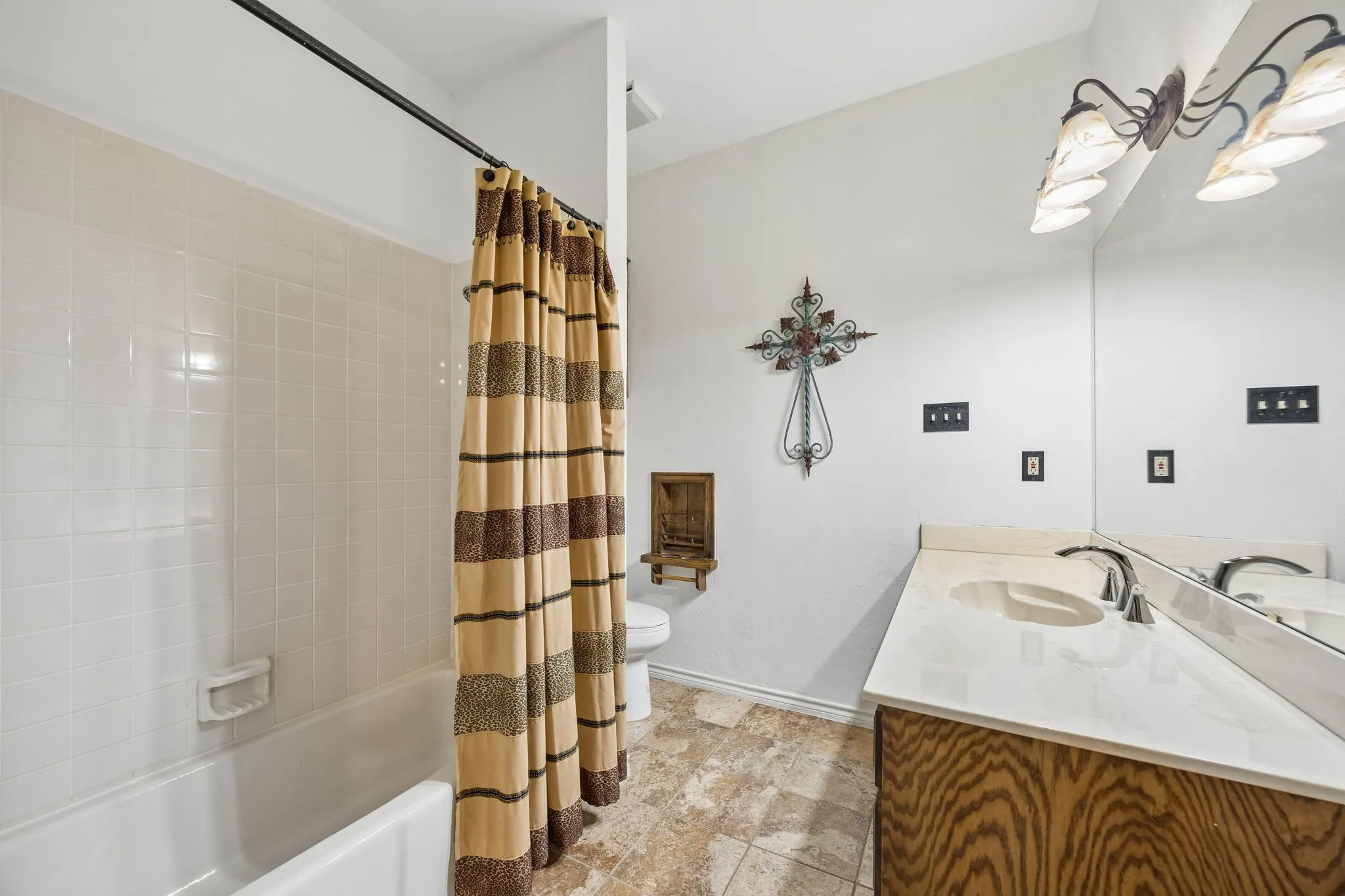 Bathroom featuring a single vanity with an integrated sink, polished chrome faucet, and expansive mirror