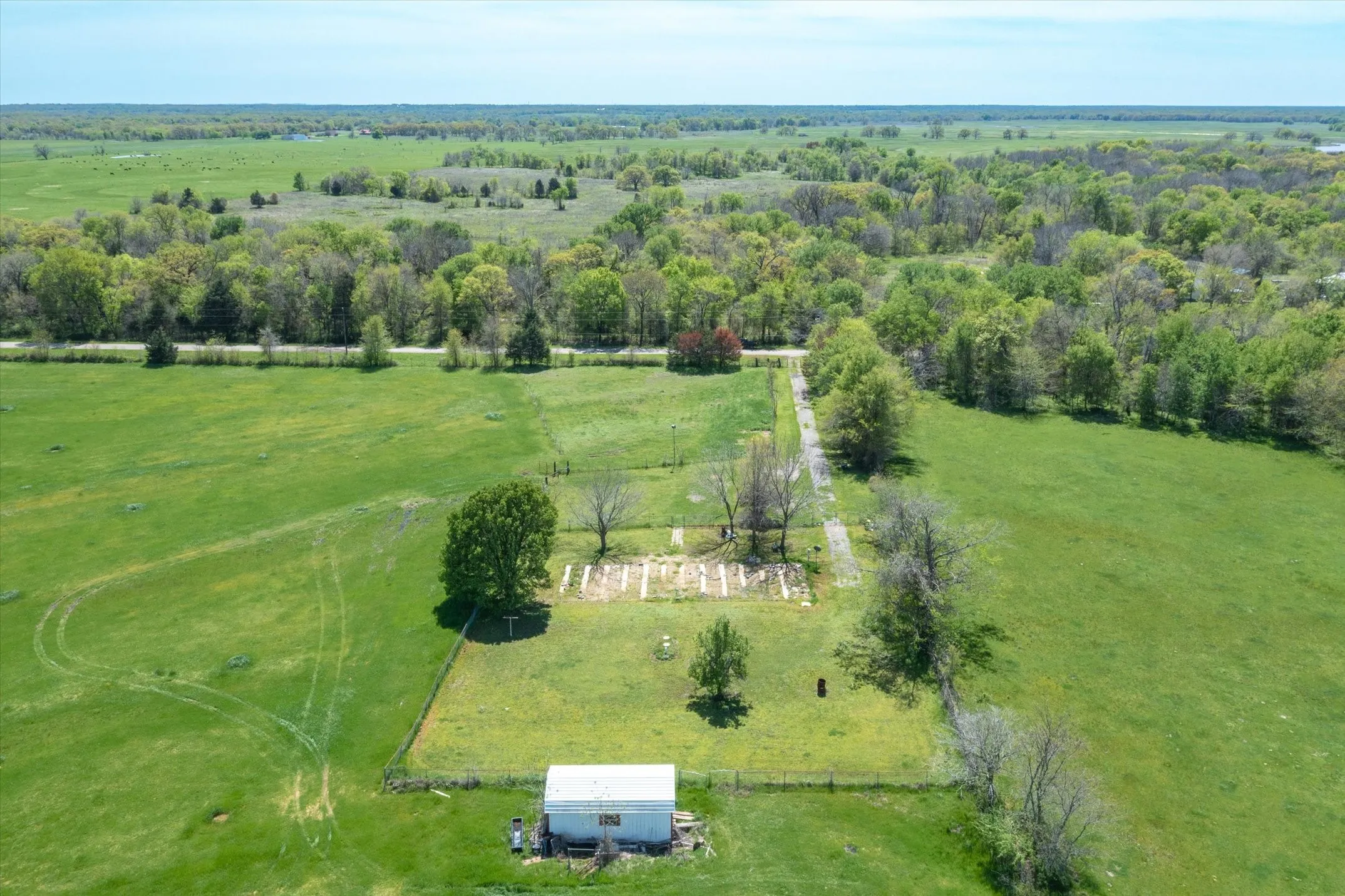 View of where homestead was previously.  White storage building does not convey with property.