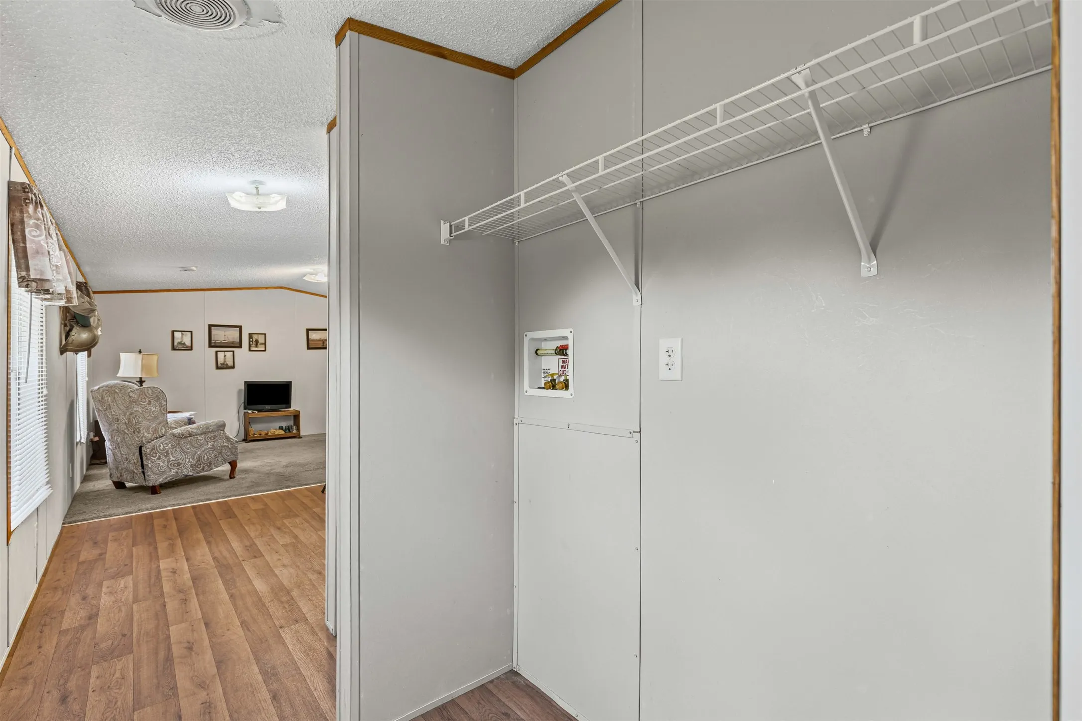 Laundry area with wood finished floors and hookup for a washing machine