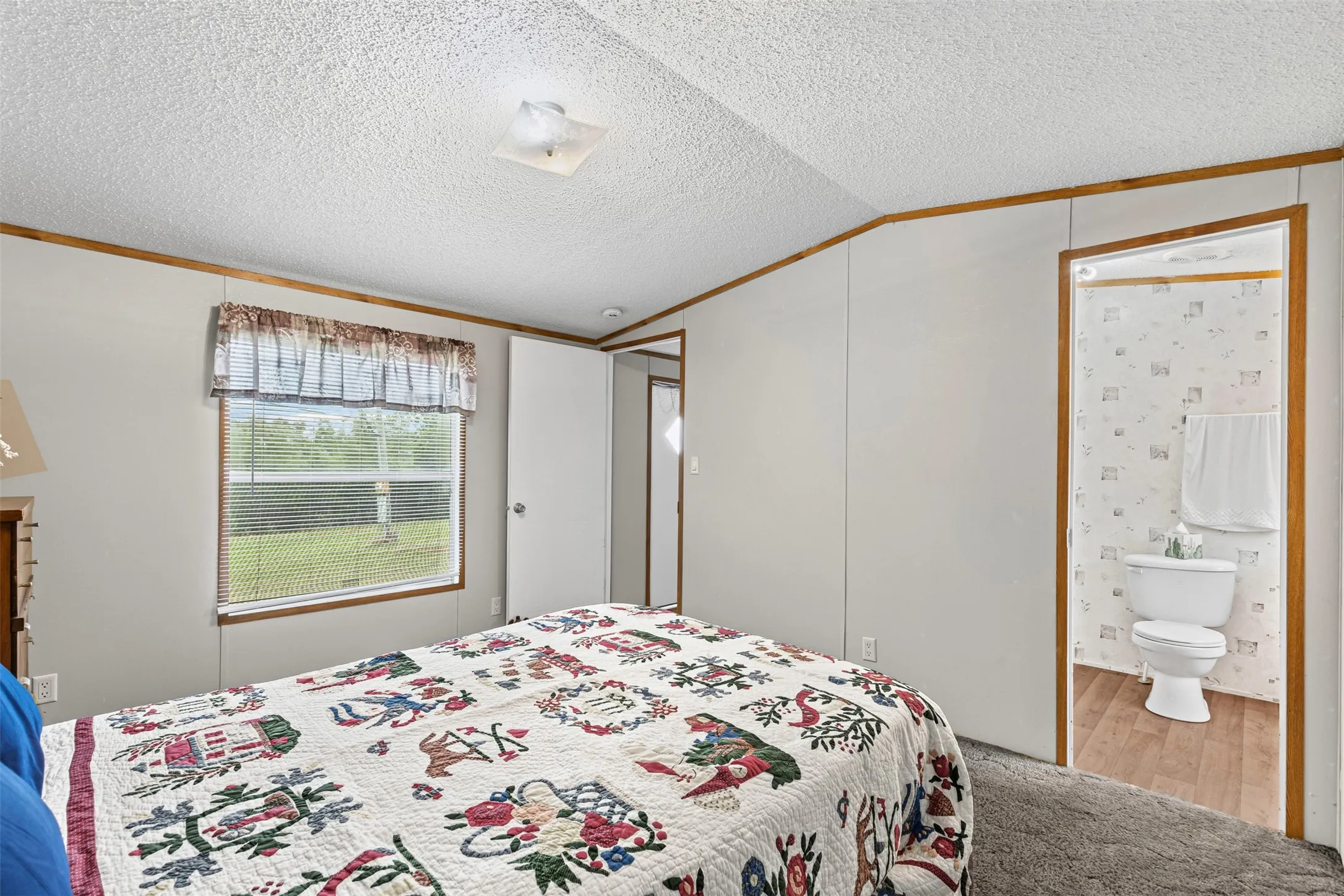 Carpeted bedroom with a window offering exterior views