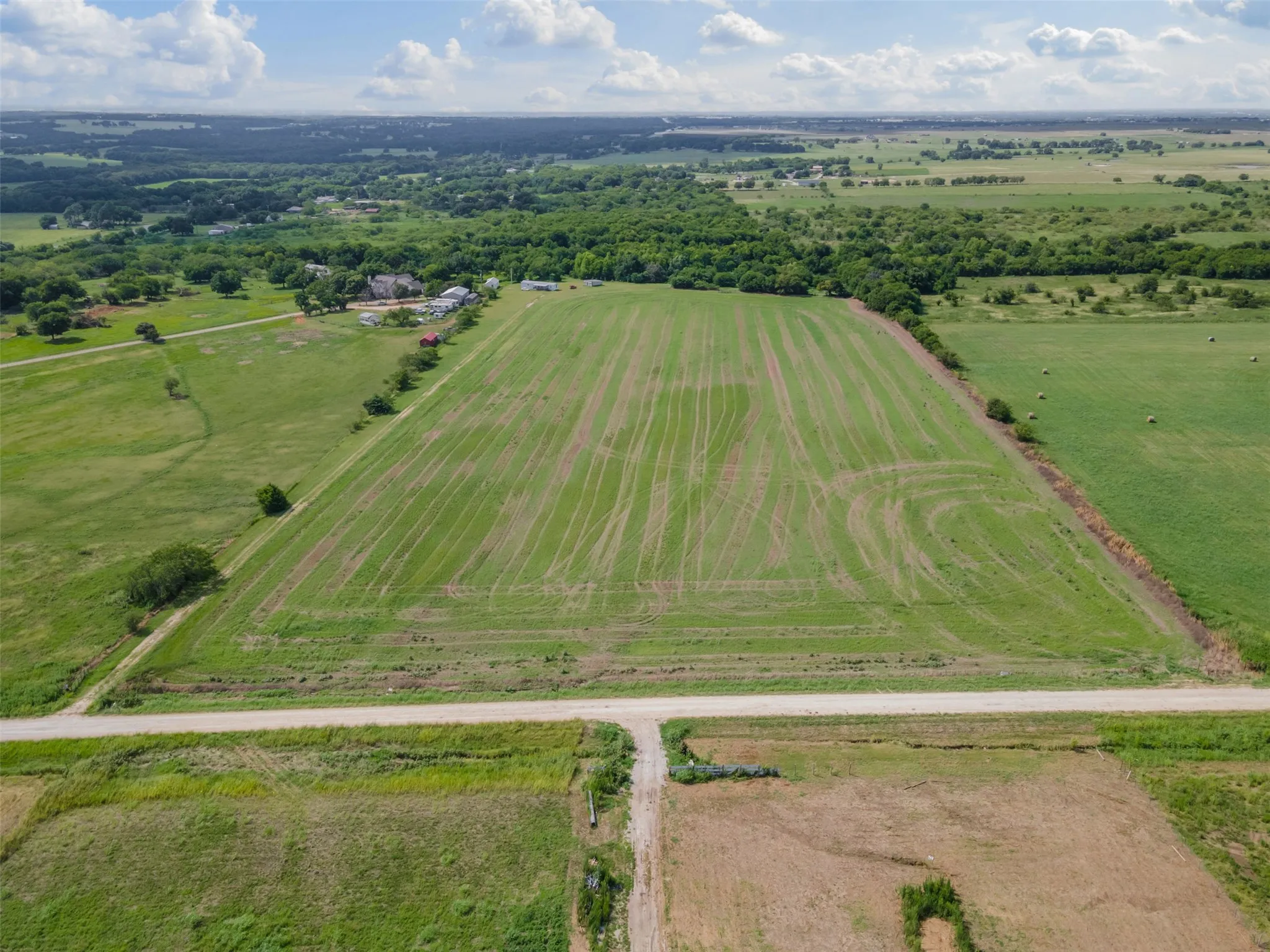 Aerial view of sparsely populated area with rows of crops