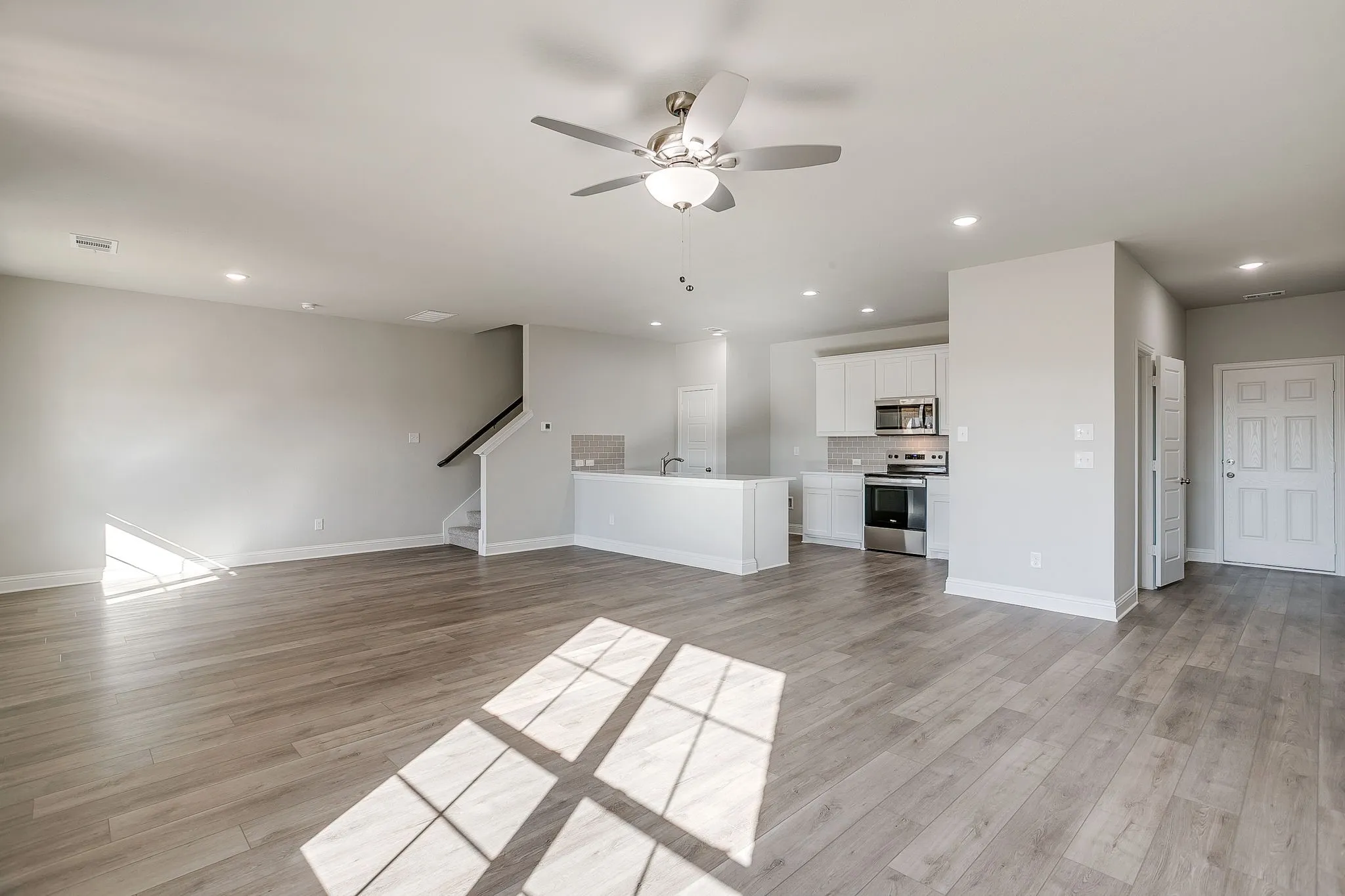 Unfurnished living room with a ceiling fan, recessed lighting, and light wood-type flooring
