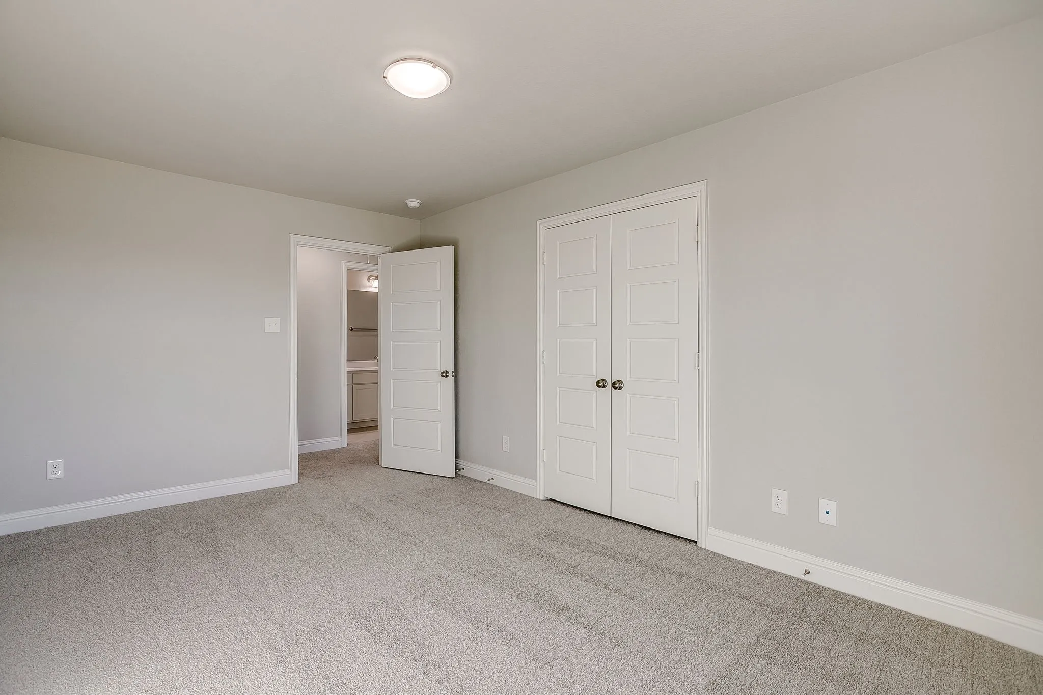 Unfurnished bedroom featuring light carpet and a closet