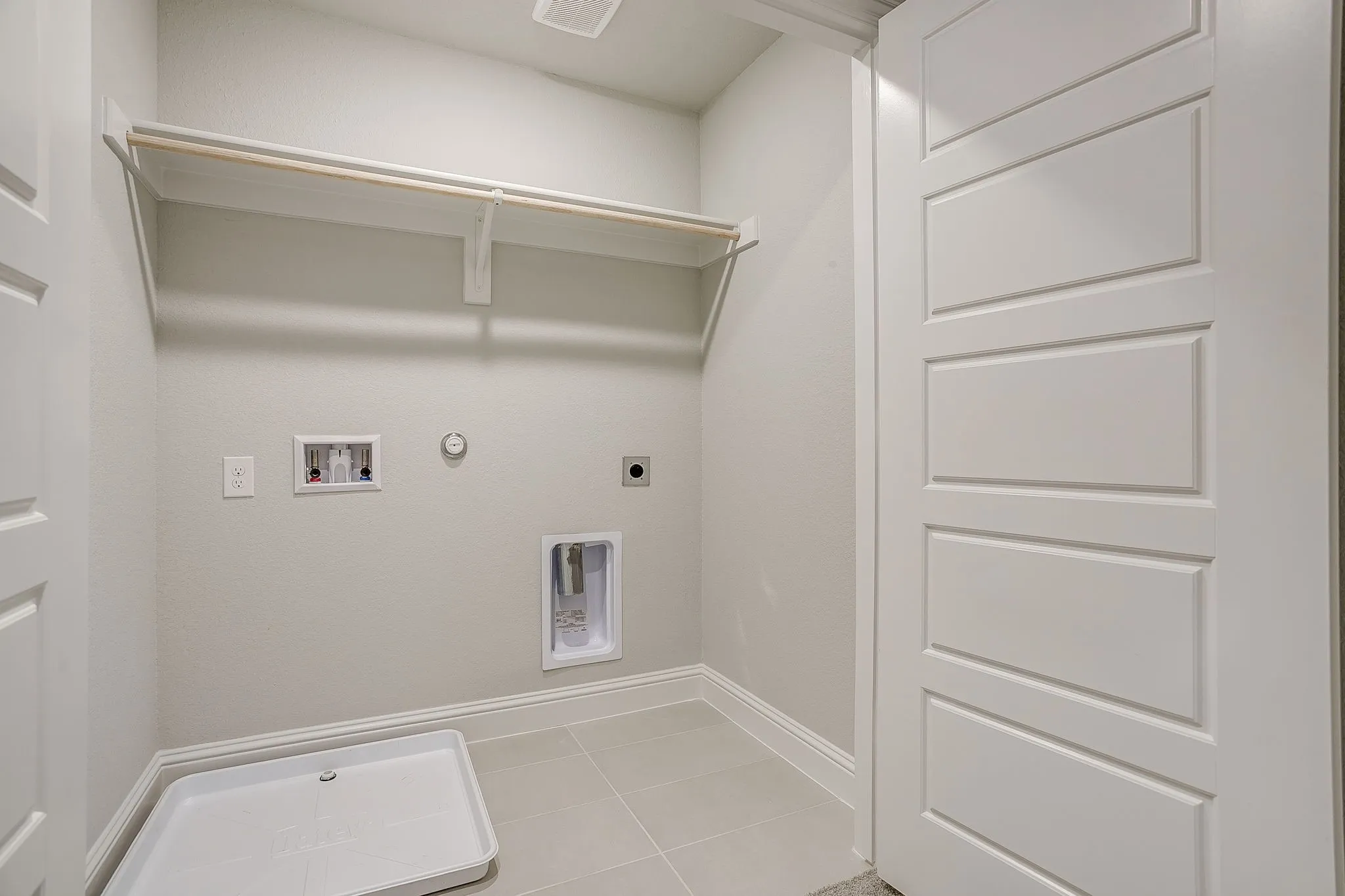 Laundry area with gas dryer hookup, hookup for an electric dryer, hookup for a washing machine, and light tile patterned floors
