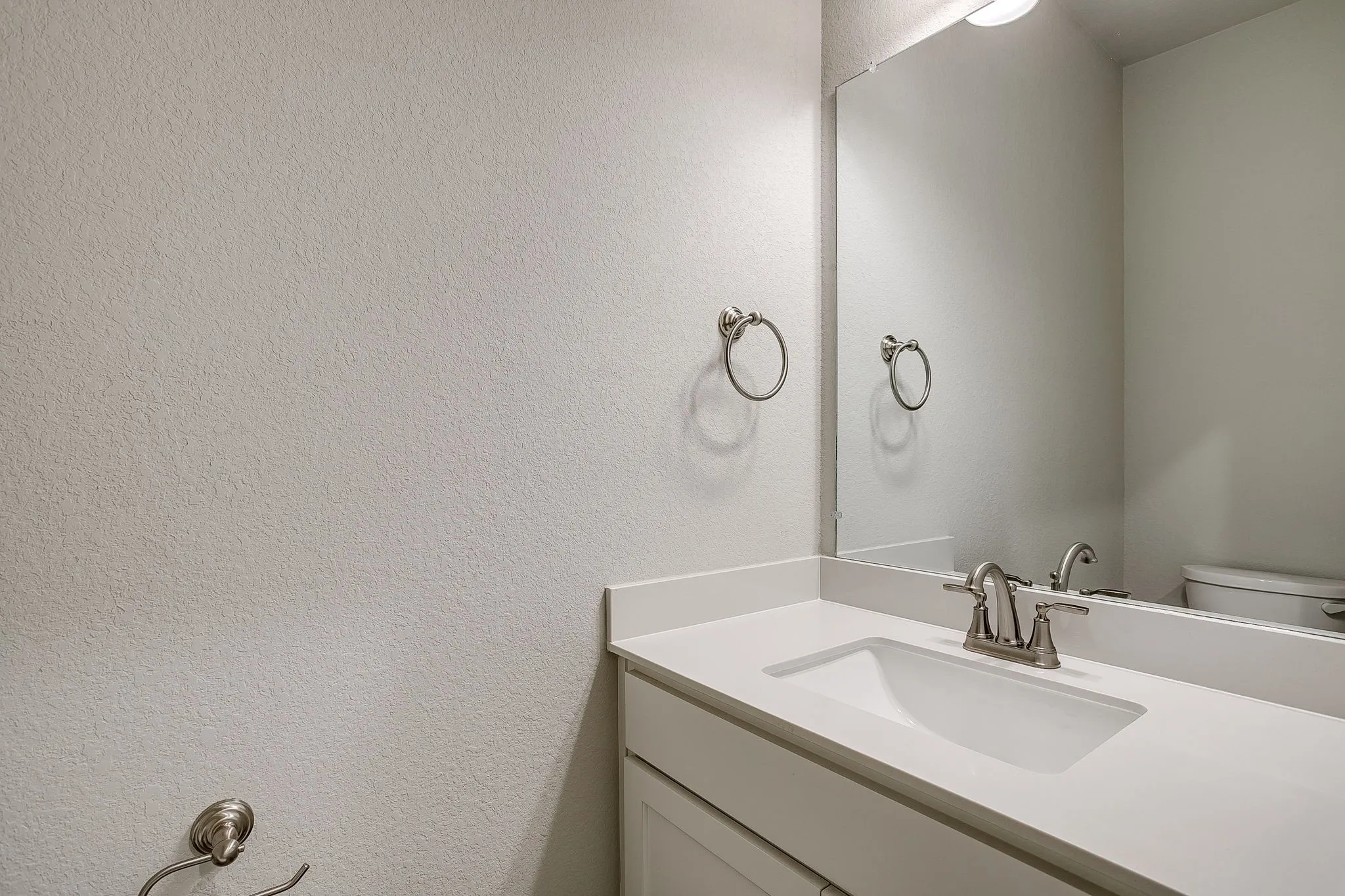 Bathroom with vanity and a textured wall