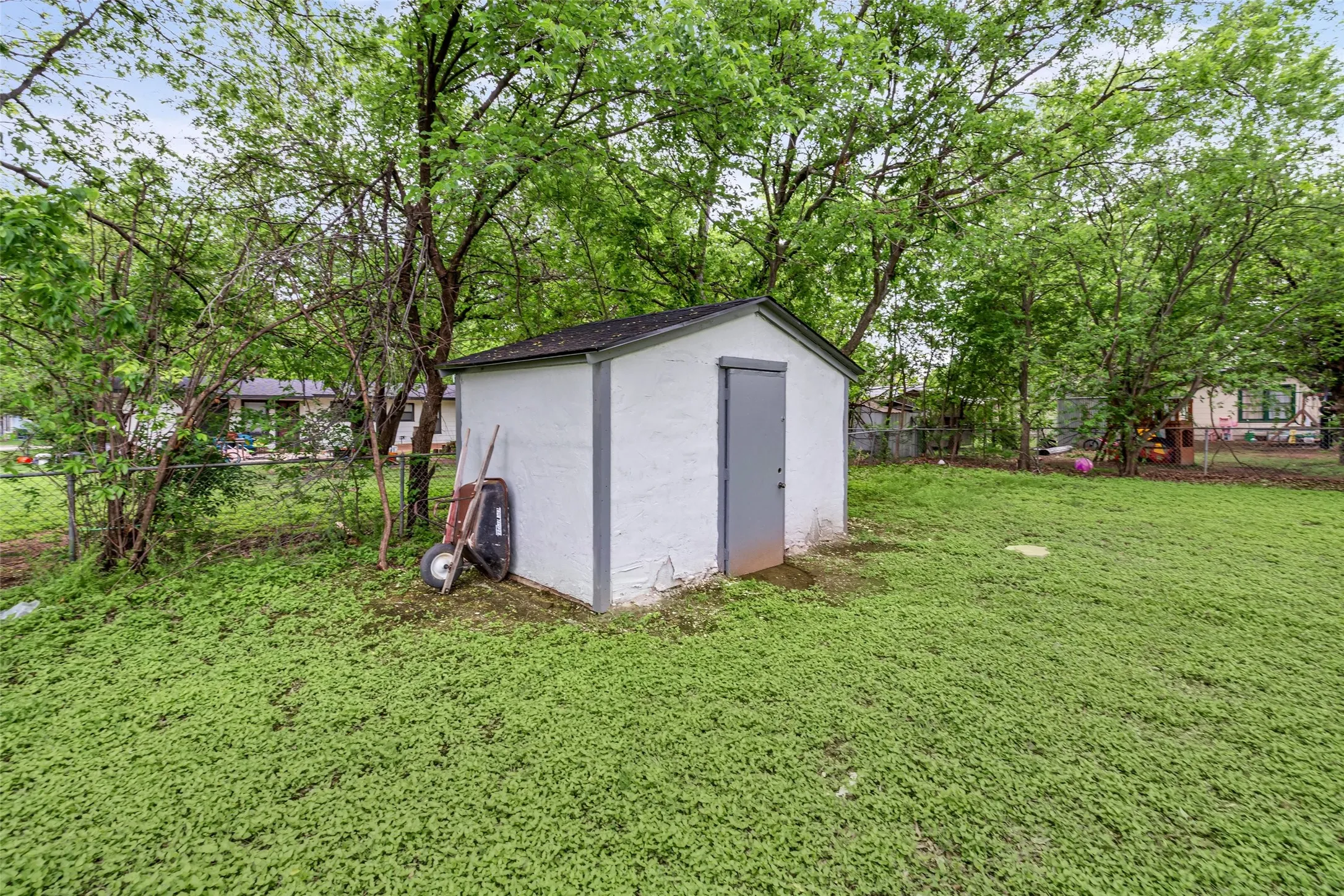 View of shed with a fenced backyard and view of scattered trees
