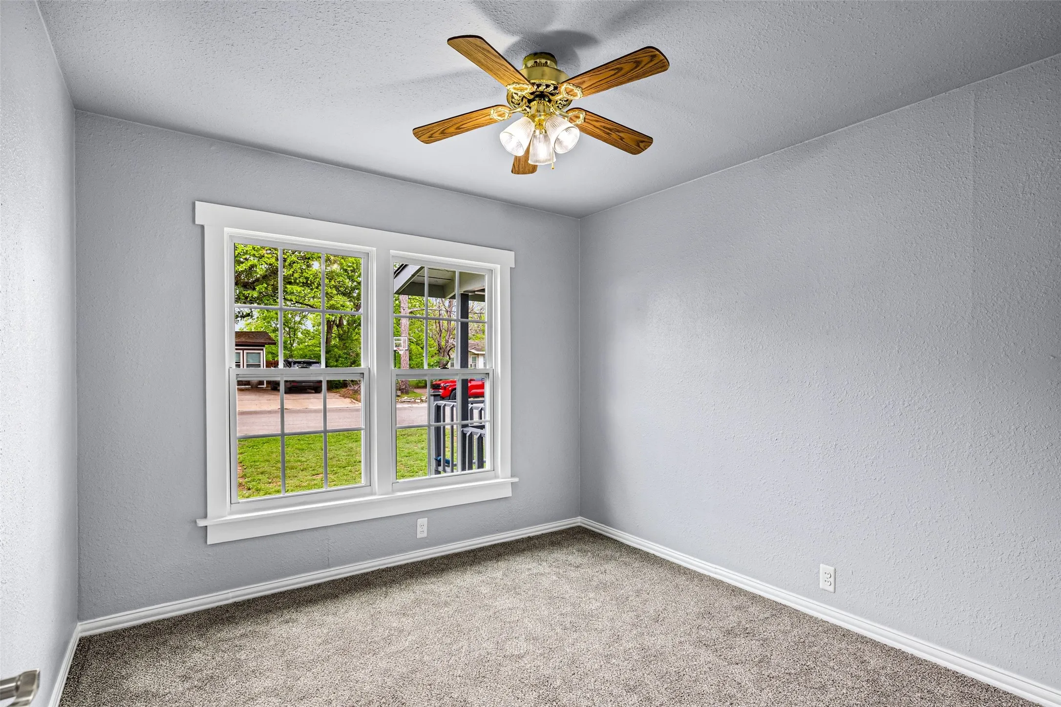 Unfurnished room featuring a textured wall, a ceiling fan, carpet, and a textured ceiling