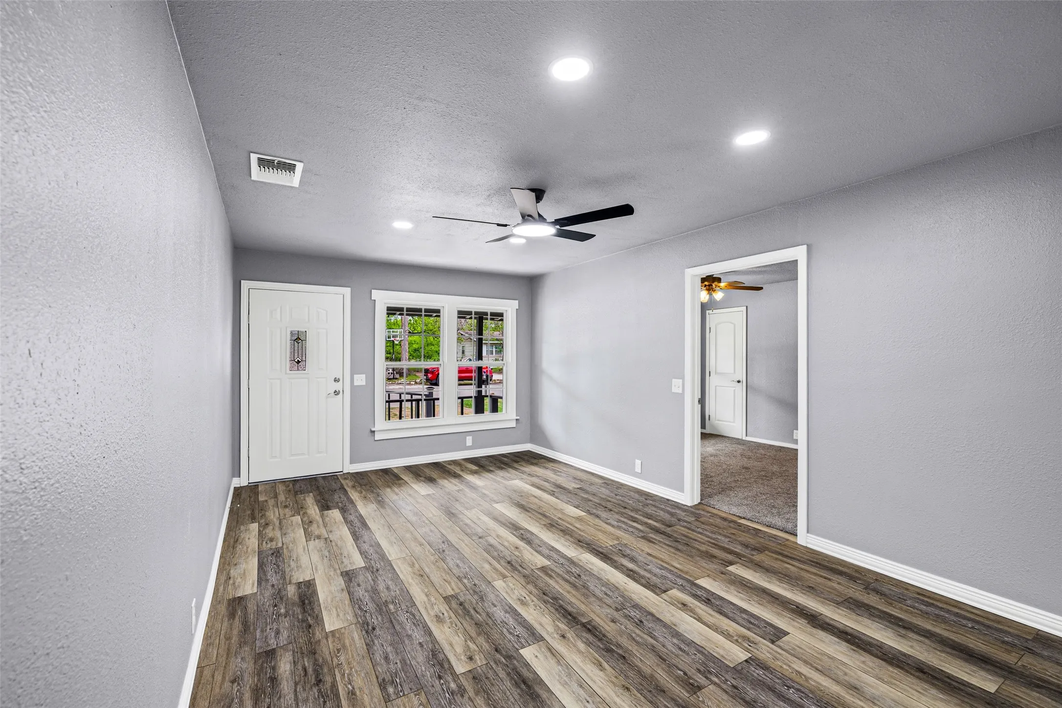 Spare room featuring a textured wall, wood finished floors, a textured ceiling, ceiling fan, and recessed lighting