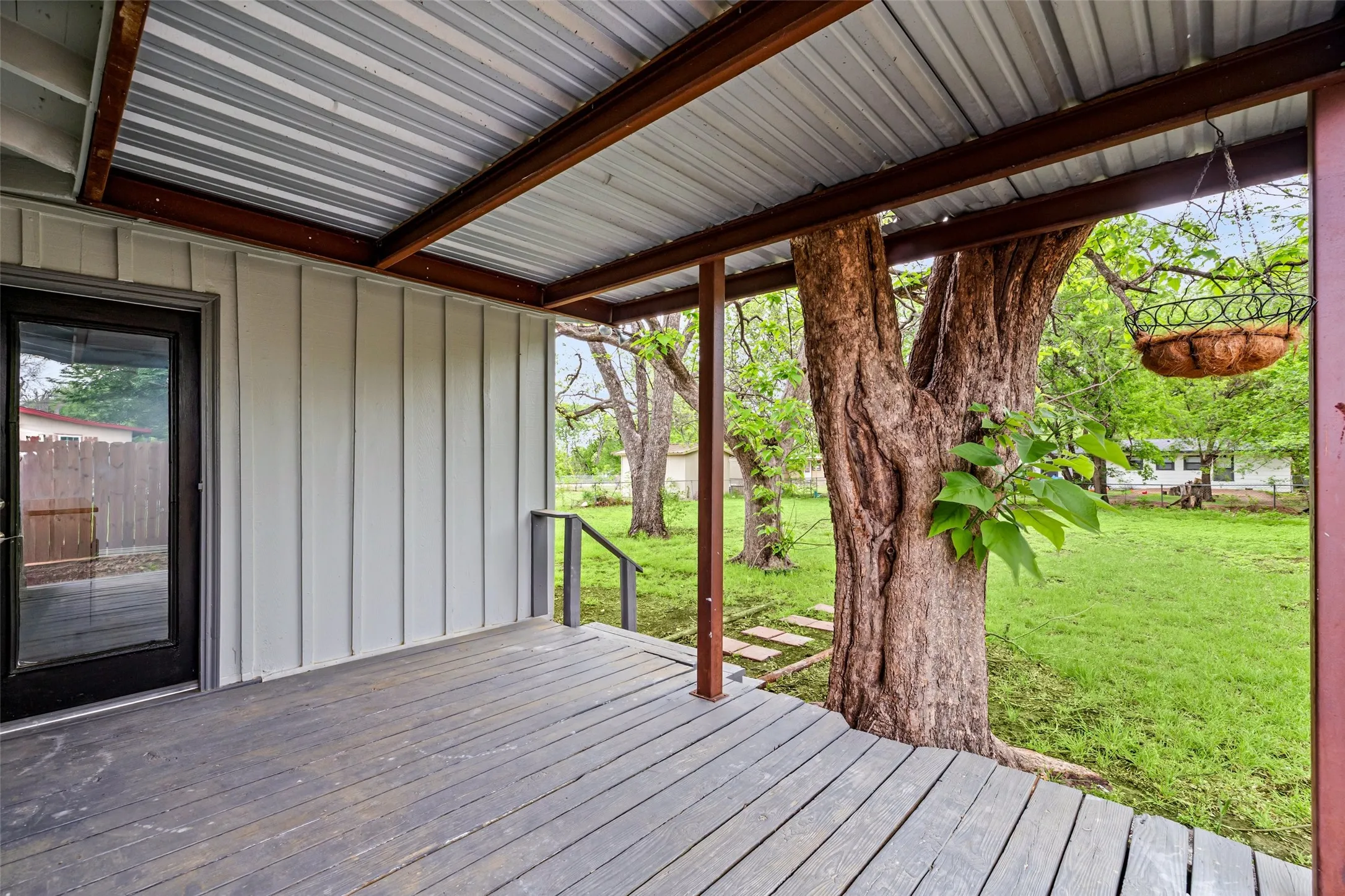Covered Deck featuring a lawn with trees