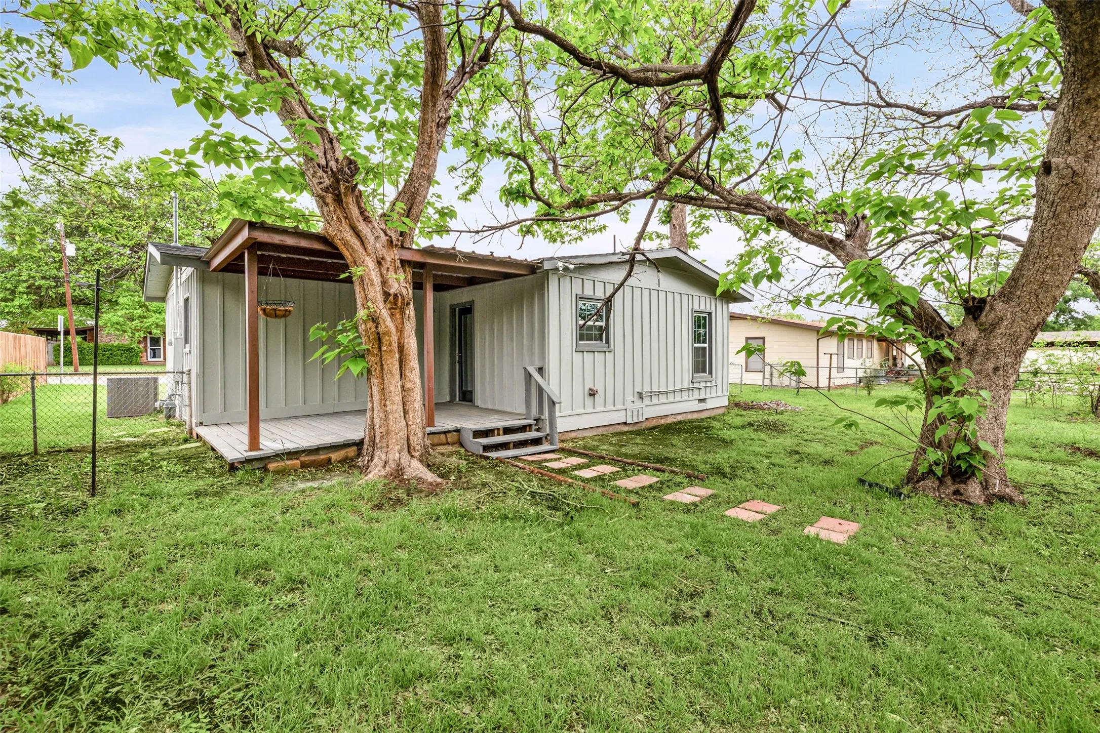 Rear view of property featuring board and batten siding and a wooden deck