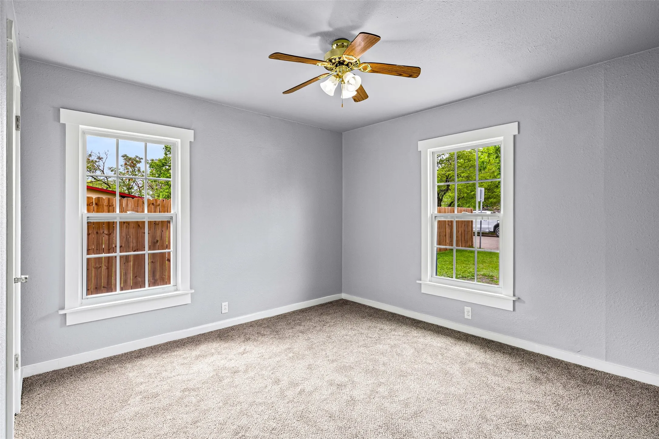 Spare room featuring a ceiling fan, carpet flooring, and a textured wall