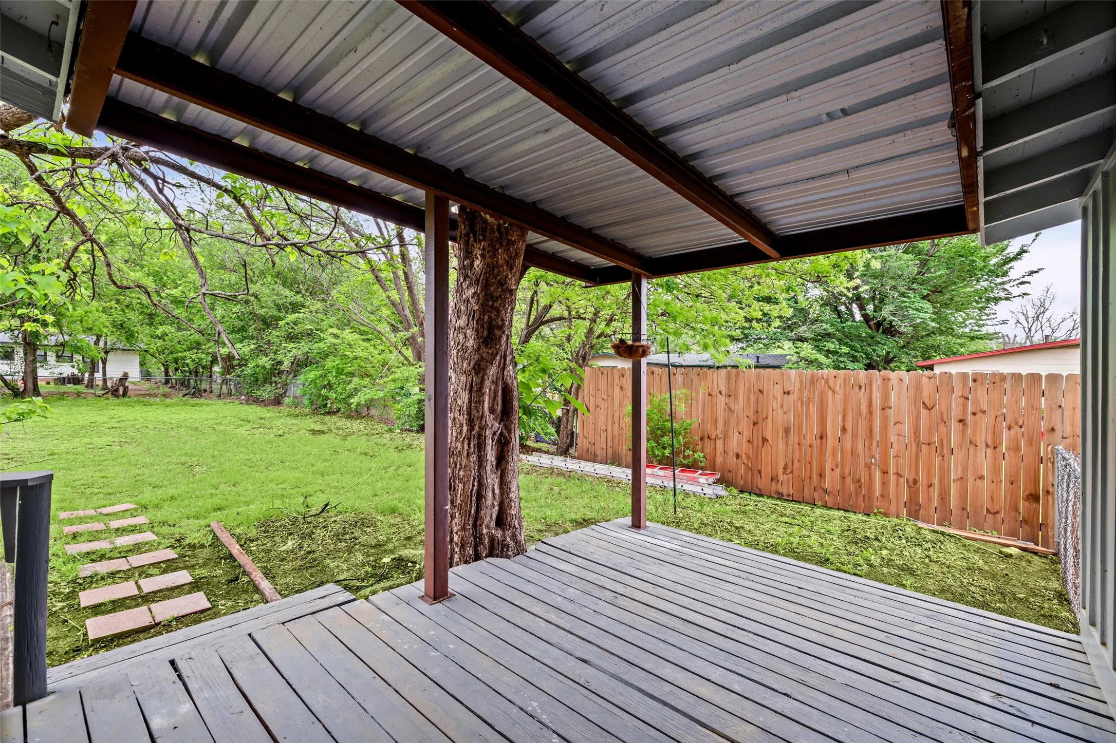 Wooden deck with a fenced backyard