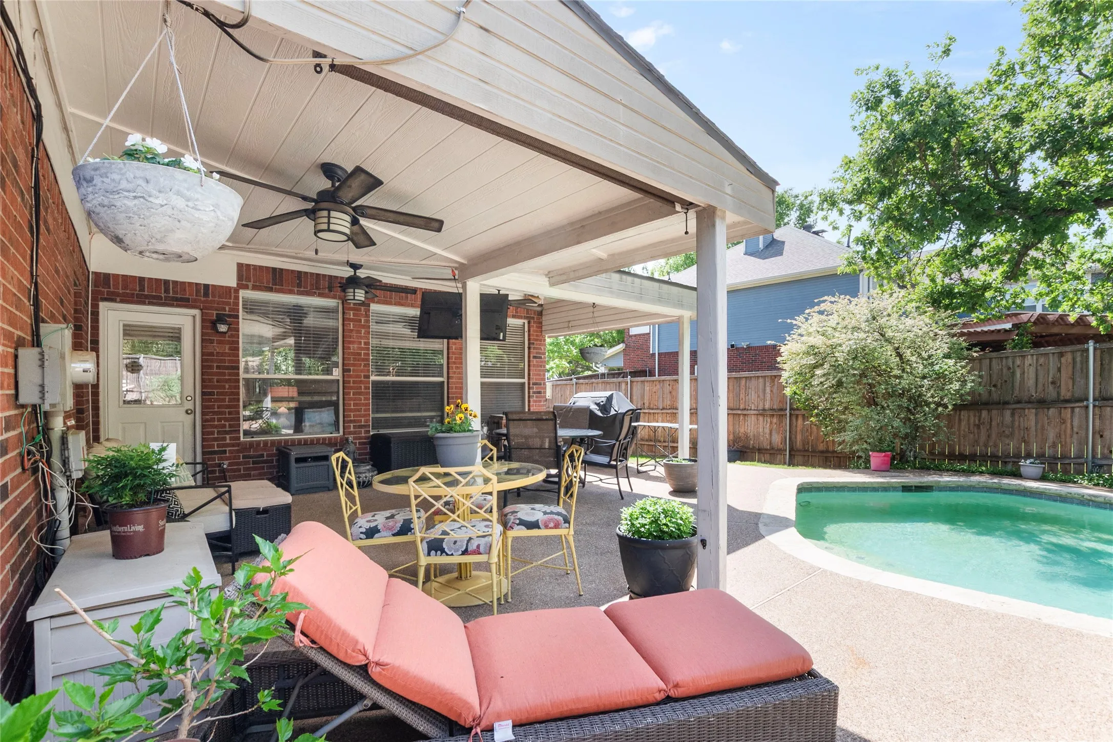 Fenced backyard with ceiling fan, a patio area, and outdoor dining space