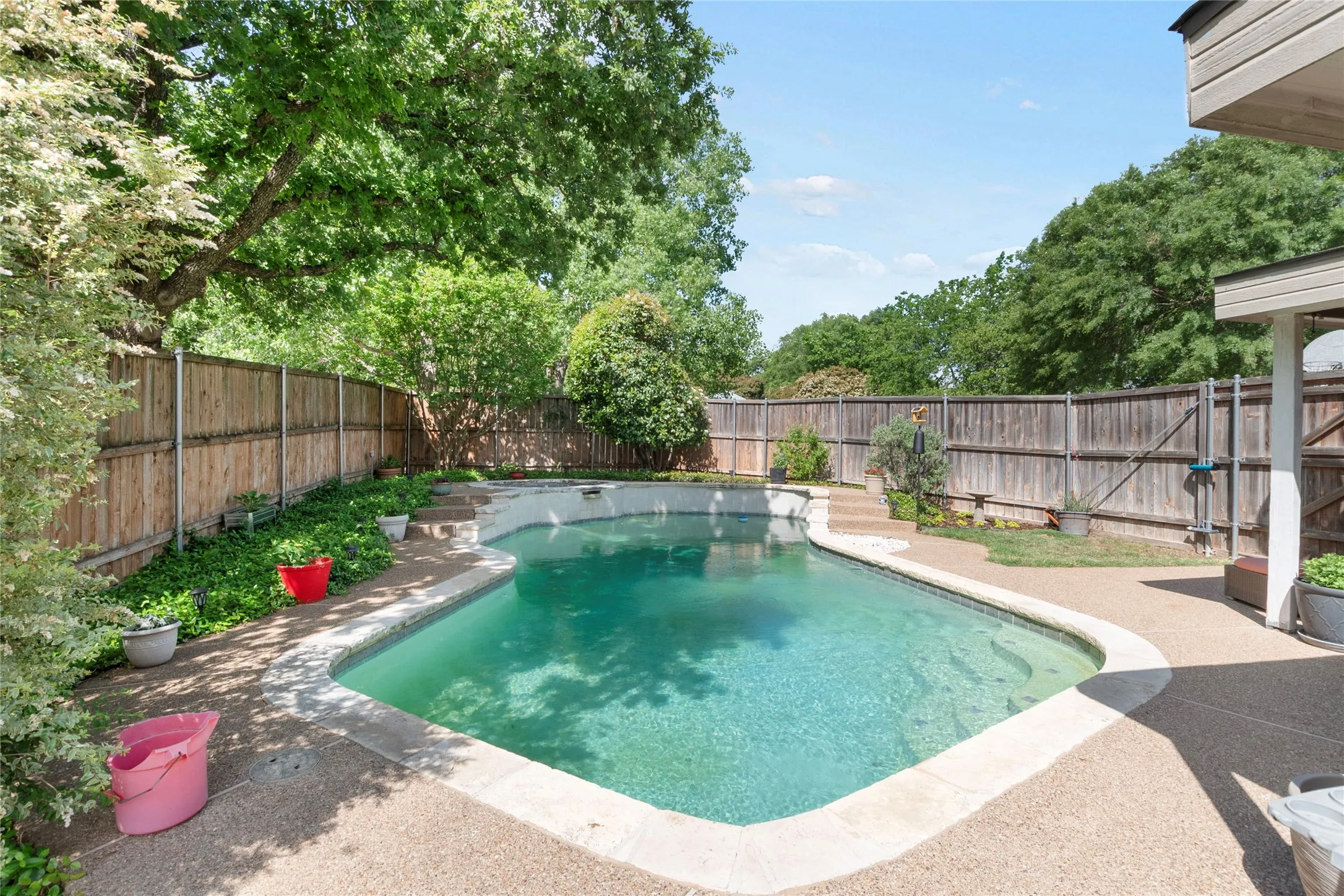View of swimming pool featuring patio surround and a fenced backyard
