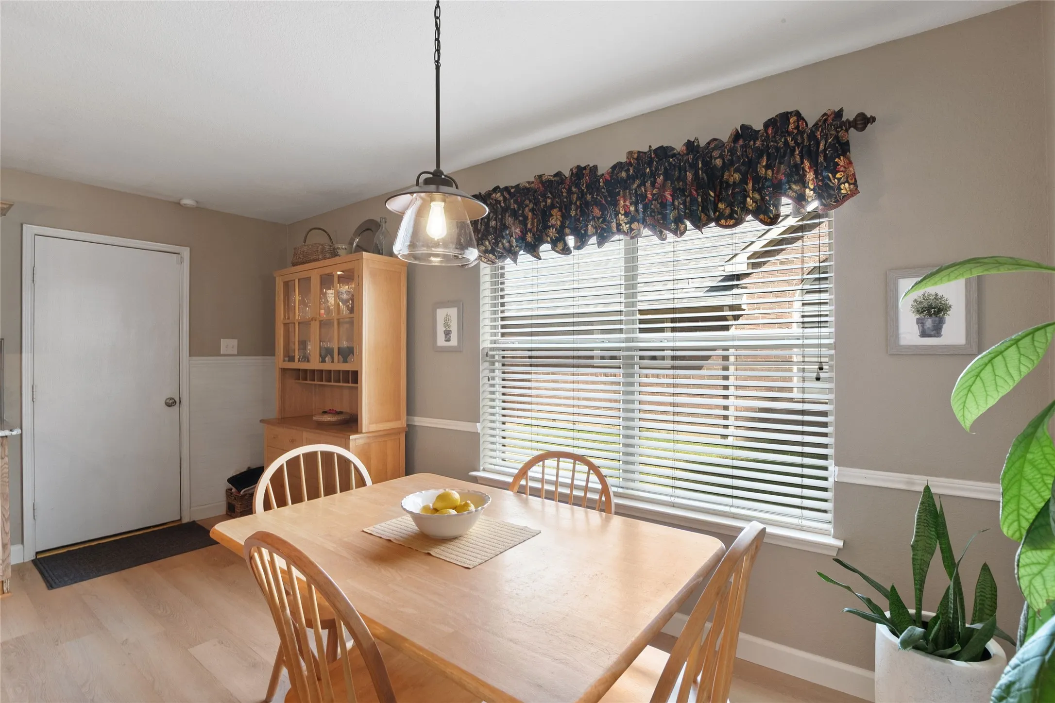 Eat in breakfast area with wood-finish flooring, a contemporary pendant light fixture, and a window with horizontal blinds
