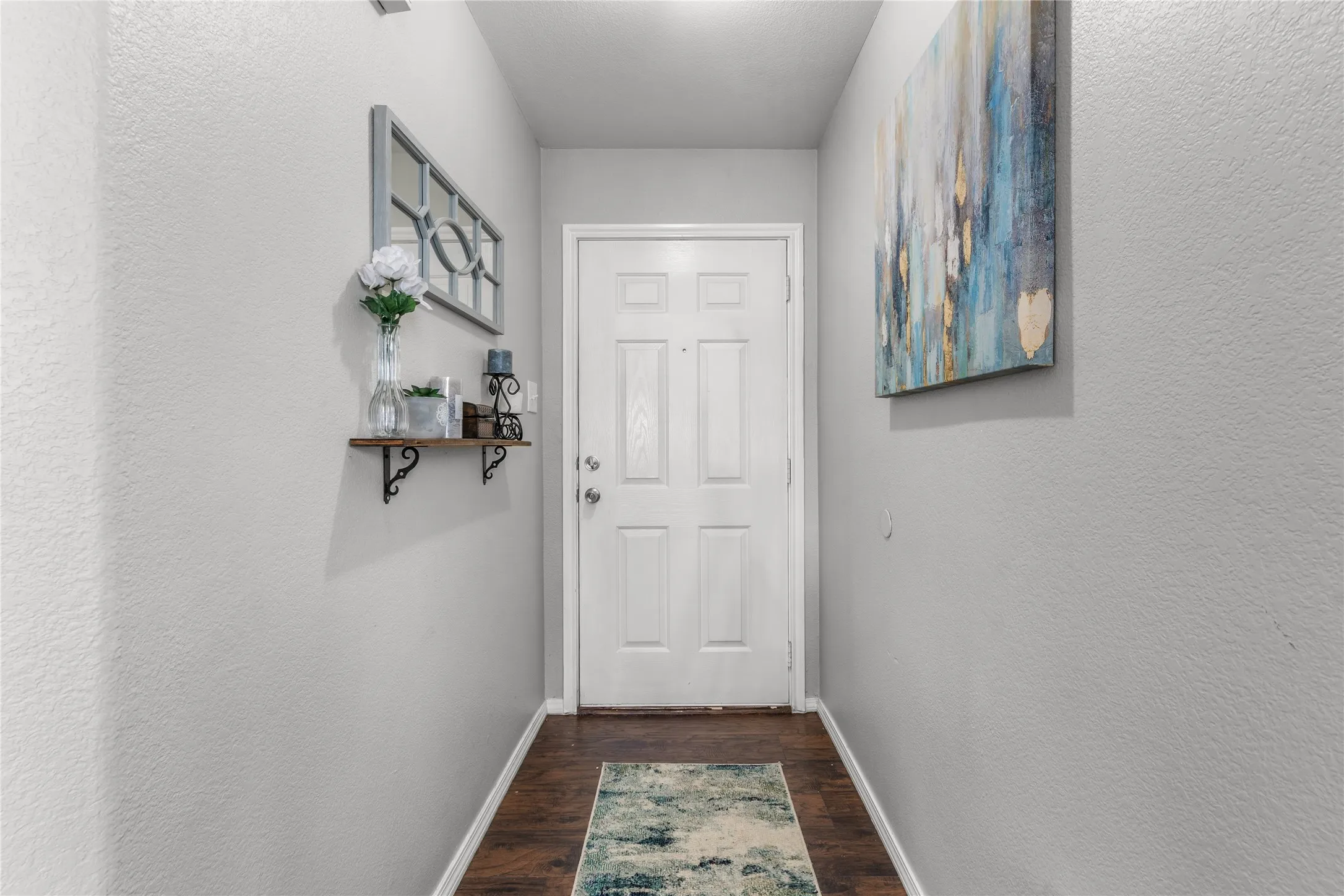 Entryway featuring a white paneled door, wood flooring, and light-colored walls
