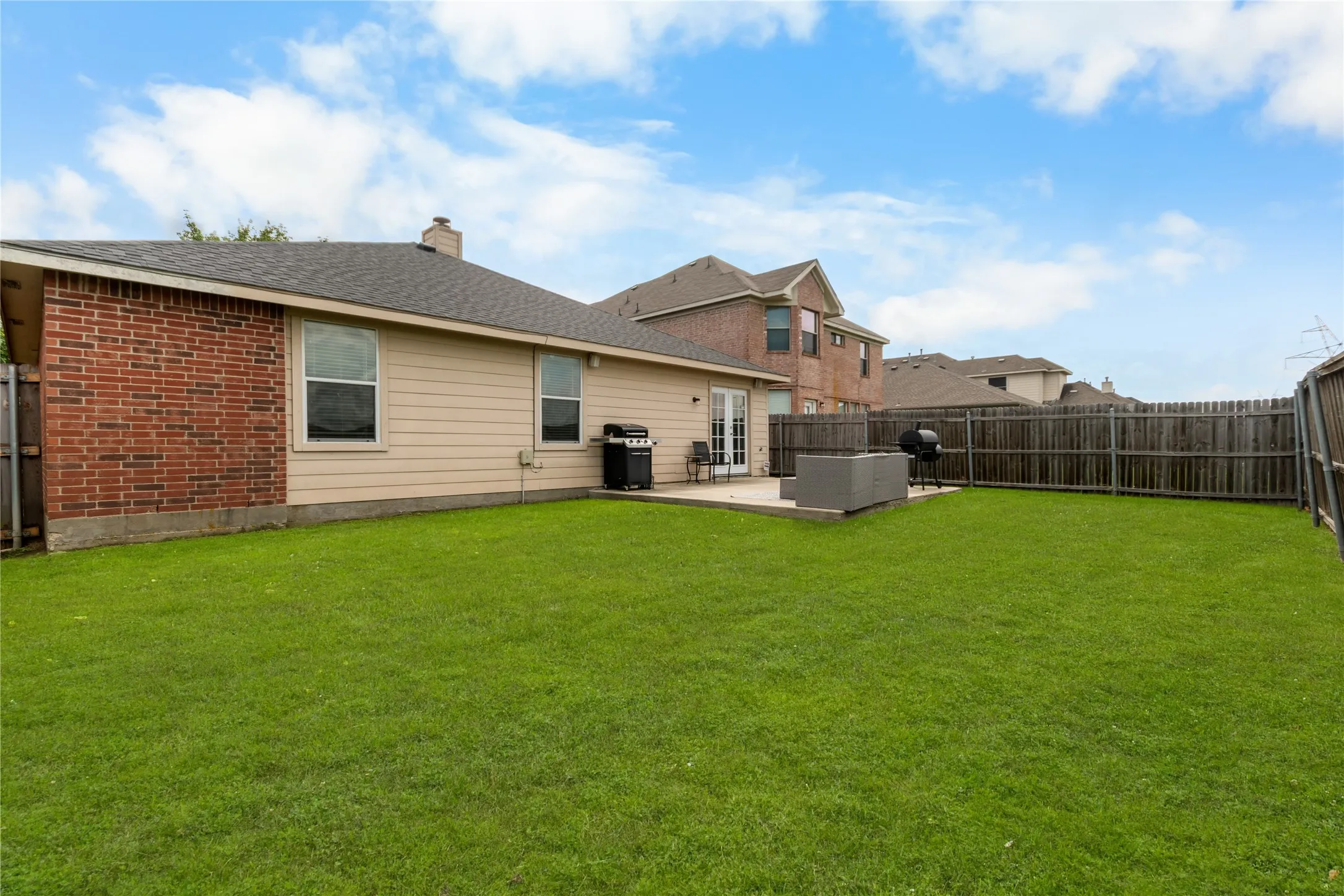 The property features a spacious backyard with a well-maintained lawn and a patio area, perfect for outdoor activities. Enhanced grass.