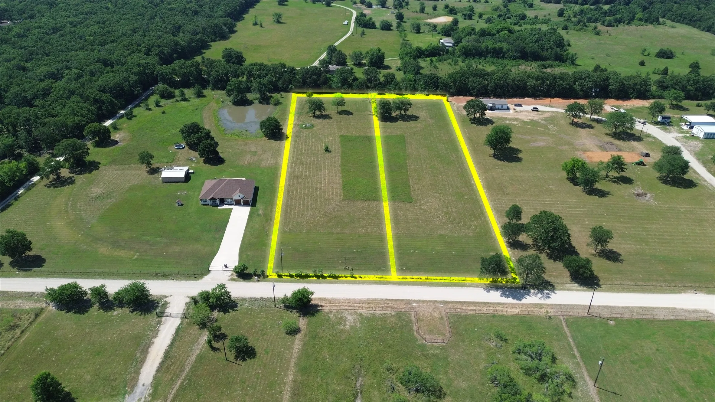 Expansive land parcel with clear boundaries, featuring a mix of open fields and scattered mature trees